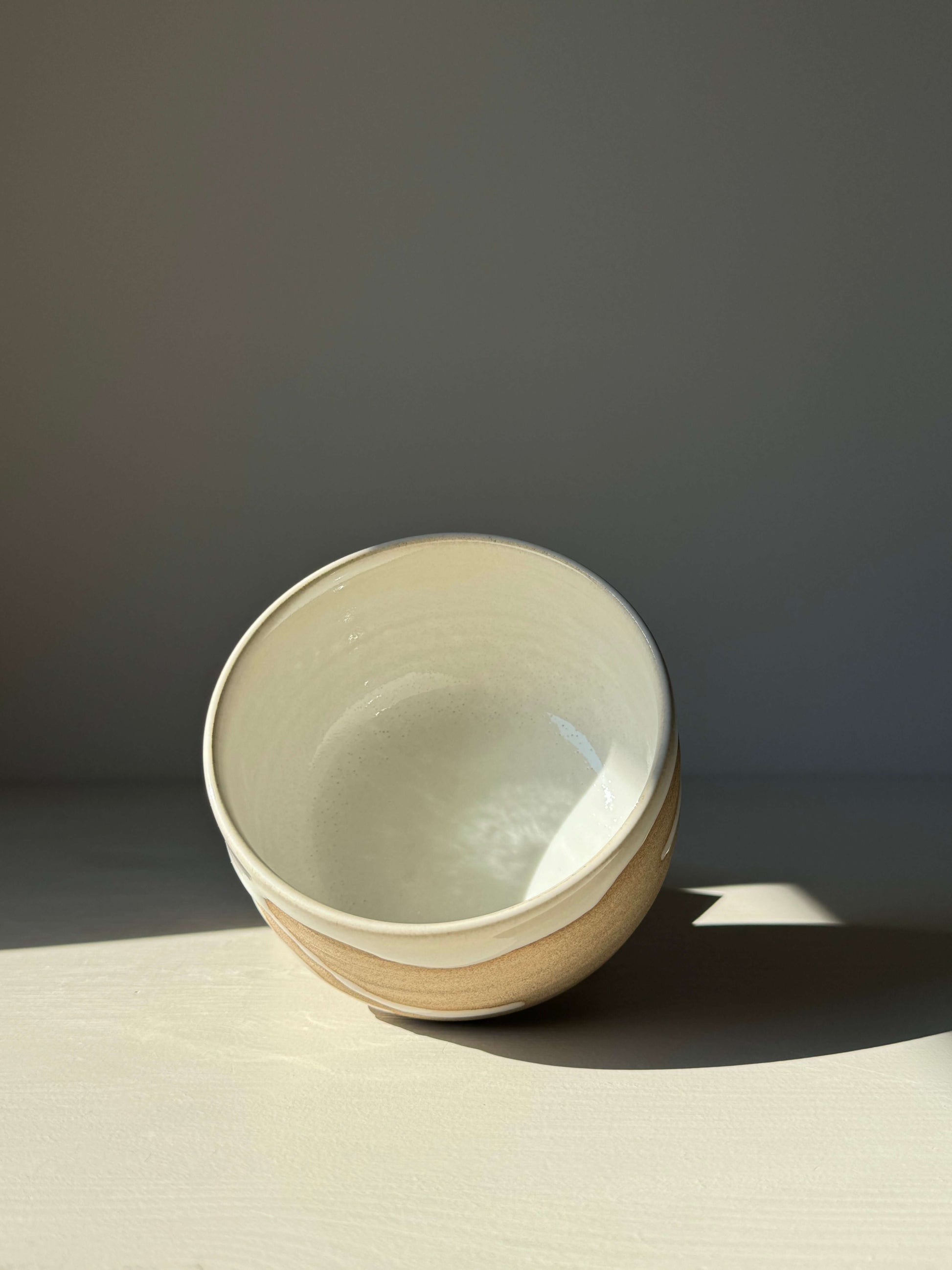 Handmade Matcha bowl from the Yuki Series, showcasing toffee clay base and glossy white glaze, creating a unique and calming piece.
