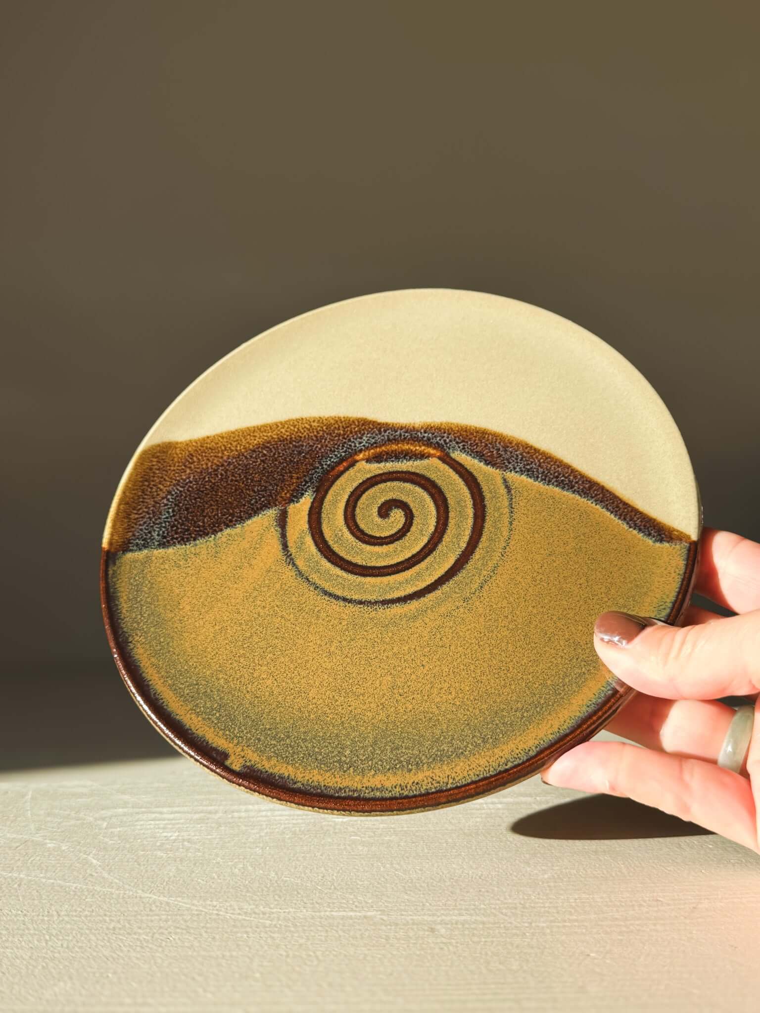 Side Plate – Inyo with creamy glaze and tenmoku swirl design, ideal for everyday use and adding natural elegance to dining.