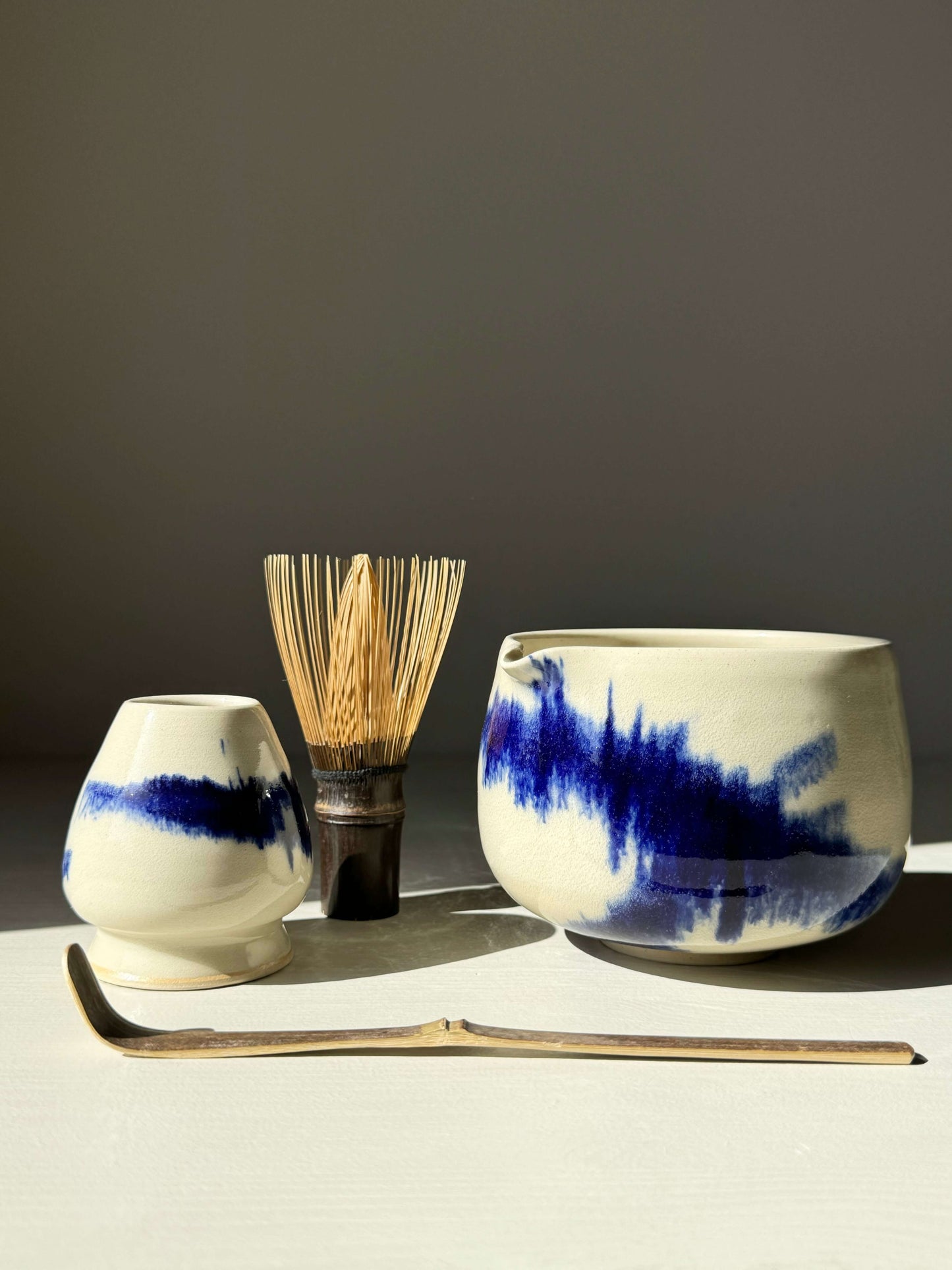 Katakuchi matcha bowl with spout from the Gosu Series, featuring cobalt blue glaze, shown with bamboo whisk and scoop.