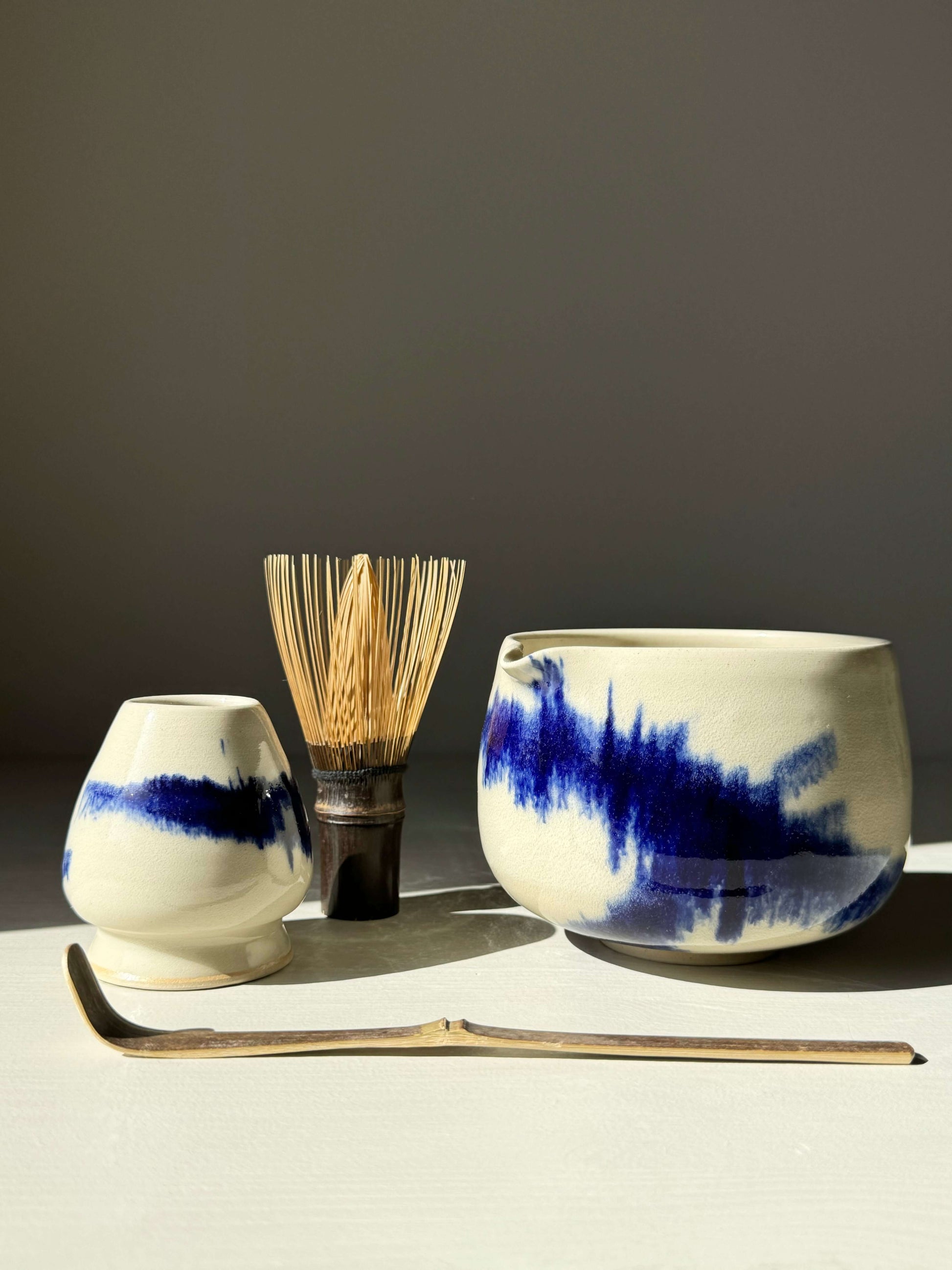 Katakuchi matcha bowl with spout from the Gosu Series, featuring cobalt blue glaze, shown with bamboo whisk and scoop.