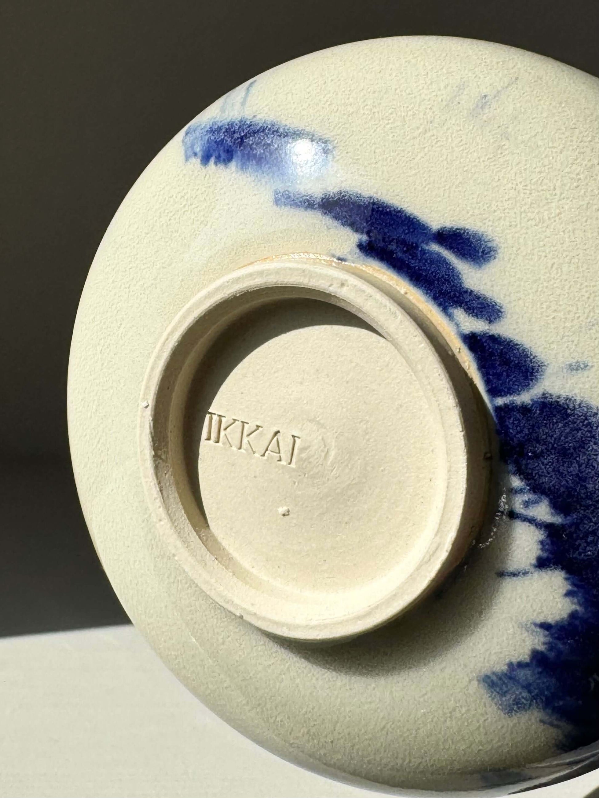 Underside of Katakuchi Matcha Bowl with spout from Gosu Series, featuring dynamic cobalt blue glaze patterns.