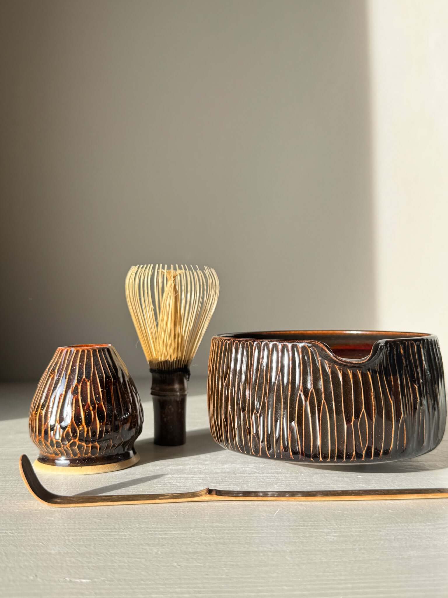 Matcha Bowl Spout – Kinsei #02 with hand-carved design and rich glaze, accompanied by traditional matcha whisk and accessory.