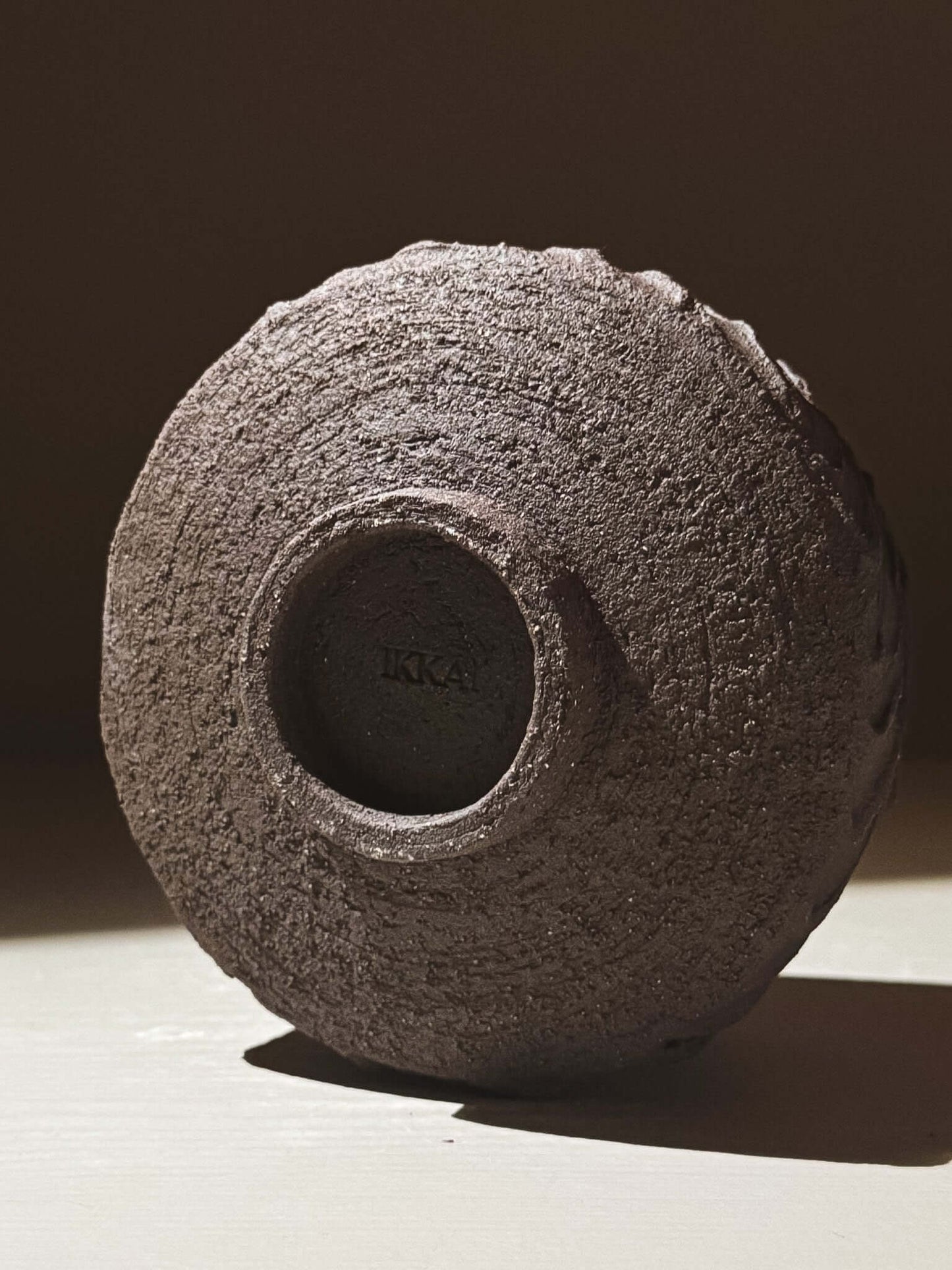 Base view of Kuro Matcha Bowl #01 showcasing textured dark brown slip and volcanic stone inspiration.