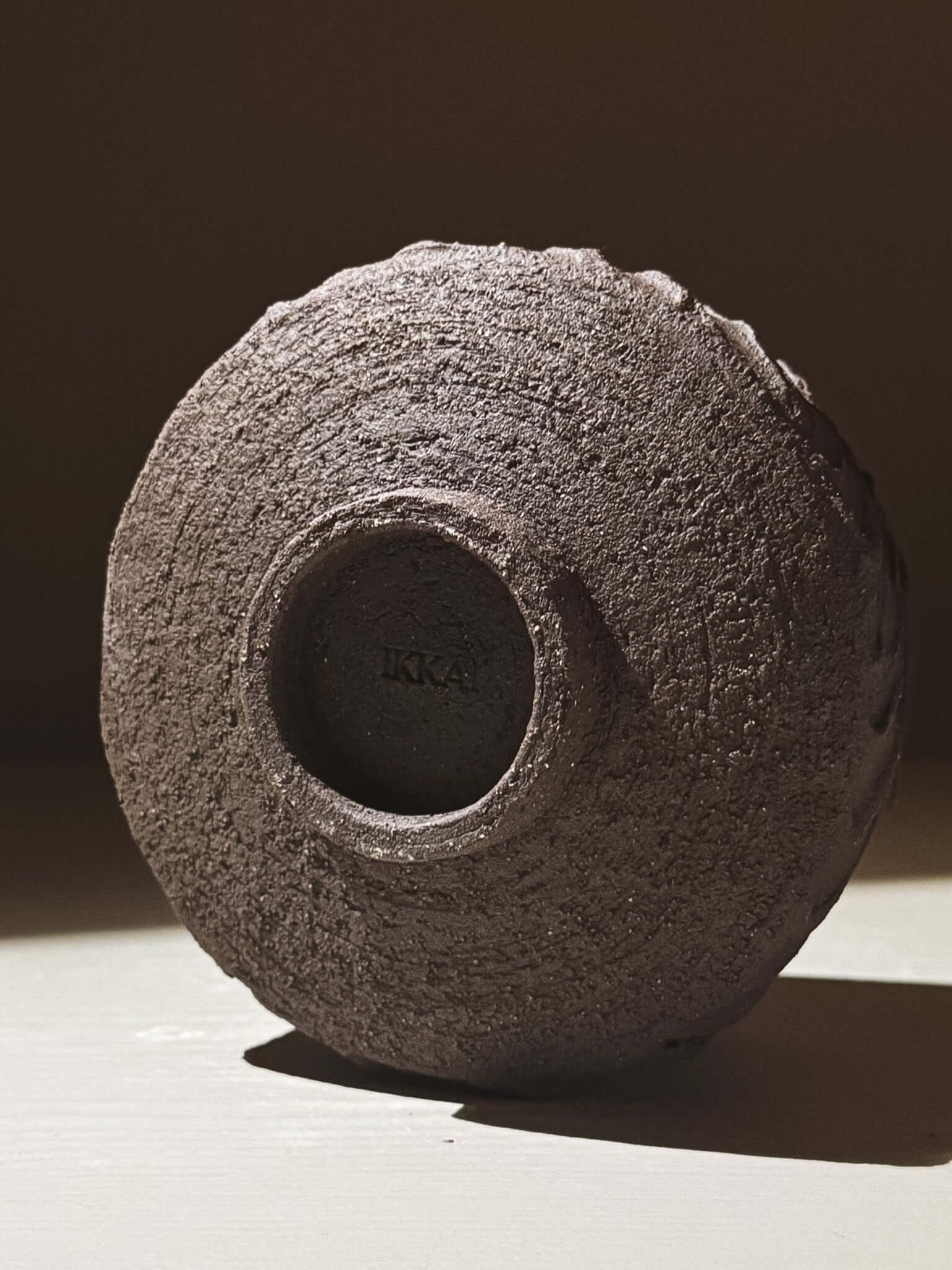 Base view of Kuro Matcha Bowl #01 showcasing textured dark brown slip and volcanic stone inspiration.