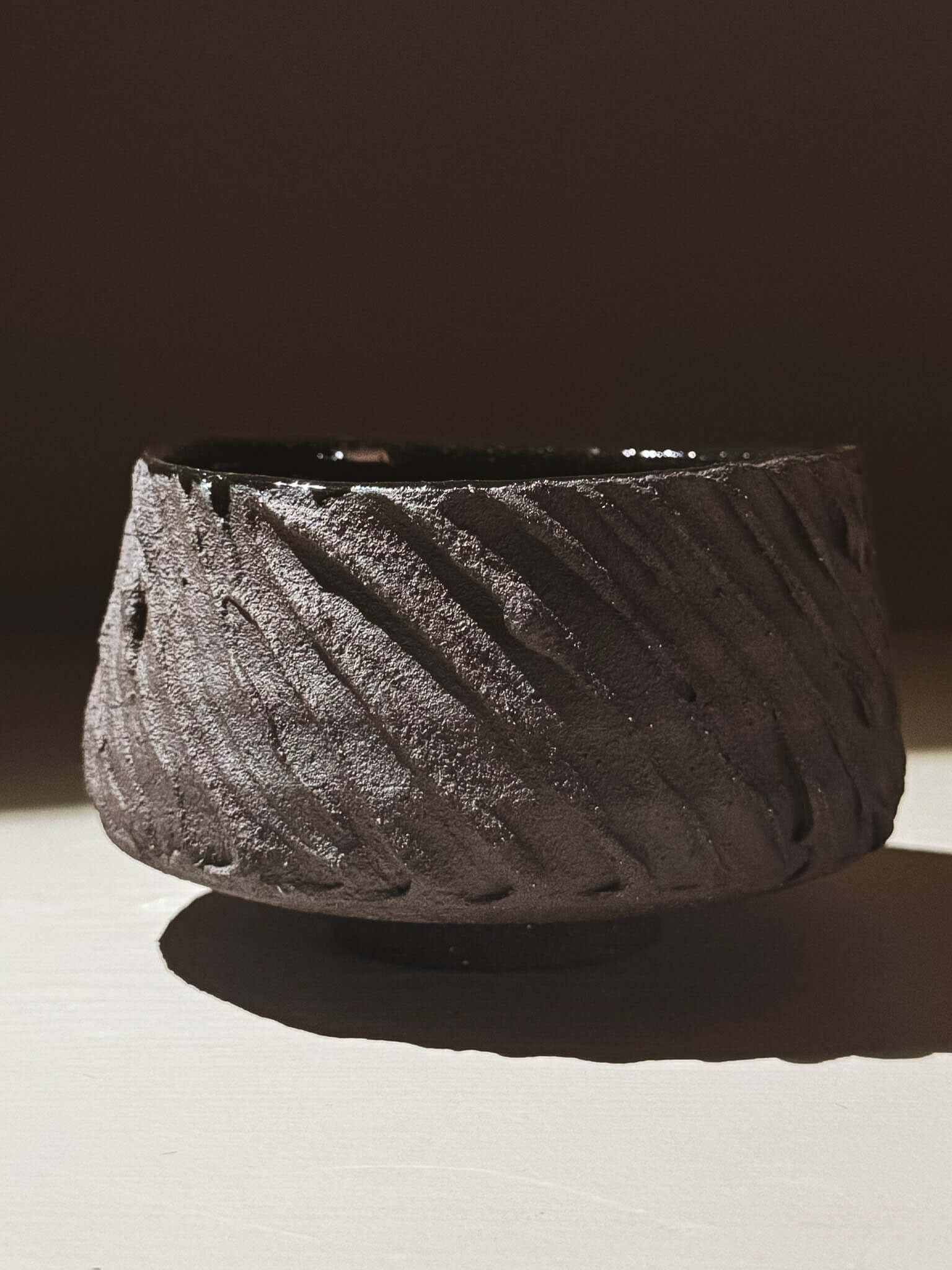 Kuro Matcha Bowl #01 with dark textured exterior and glossy interior, inspired by volcanic stone and earthy textures.