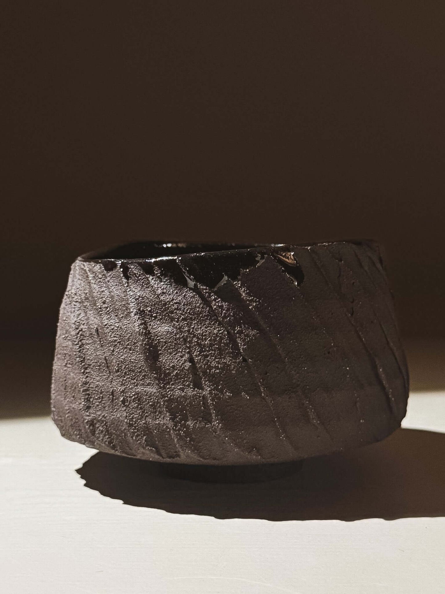 Kuro Matcha Bowl #05 with dark textured exterior and glossy interior, highlighting its volcanic stone-inspired design.