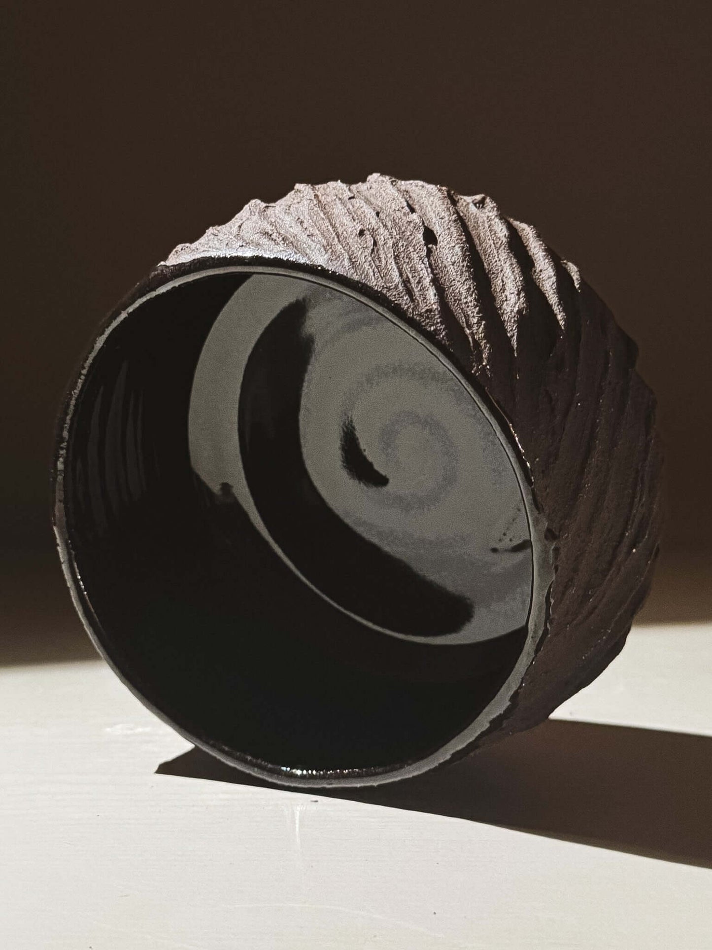 Kuro Matcha Bowl #08 with textured dark brown exterior and glossy black interior, inspired by volcanic stone and earthy textures.