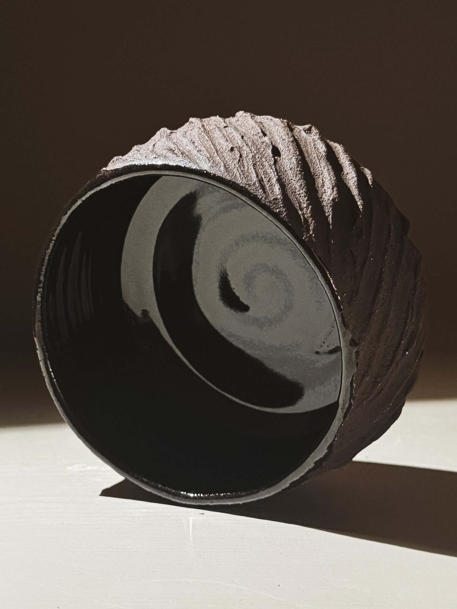 Kuro Matcha Bowl #08 with textured dark brown exterior and glossy black interior, inspired by volcanic stone and earthy textures.