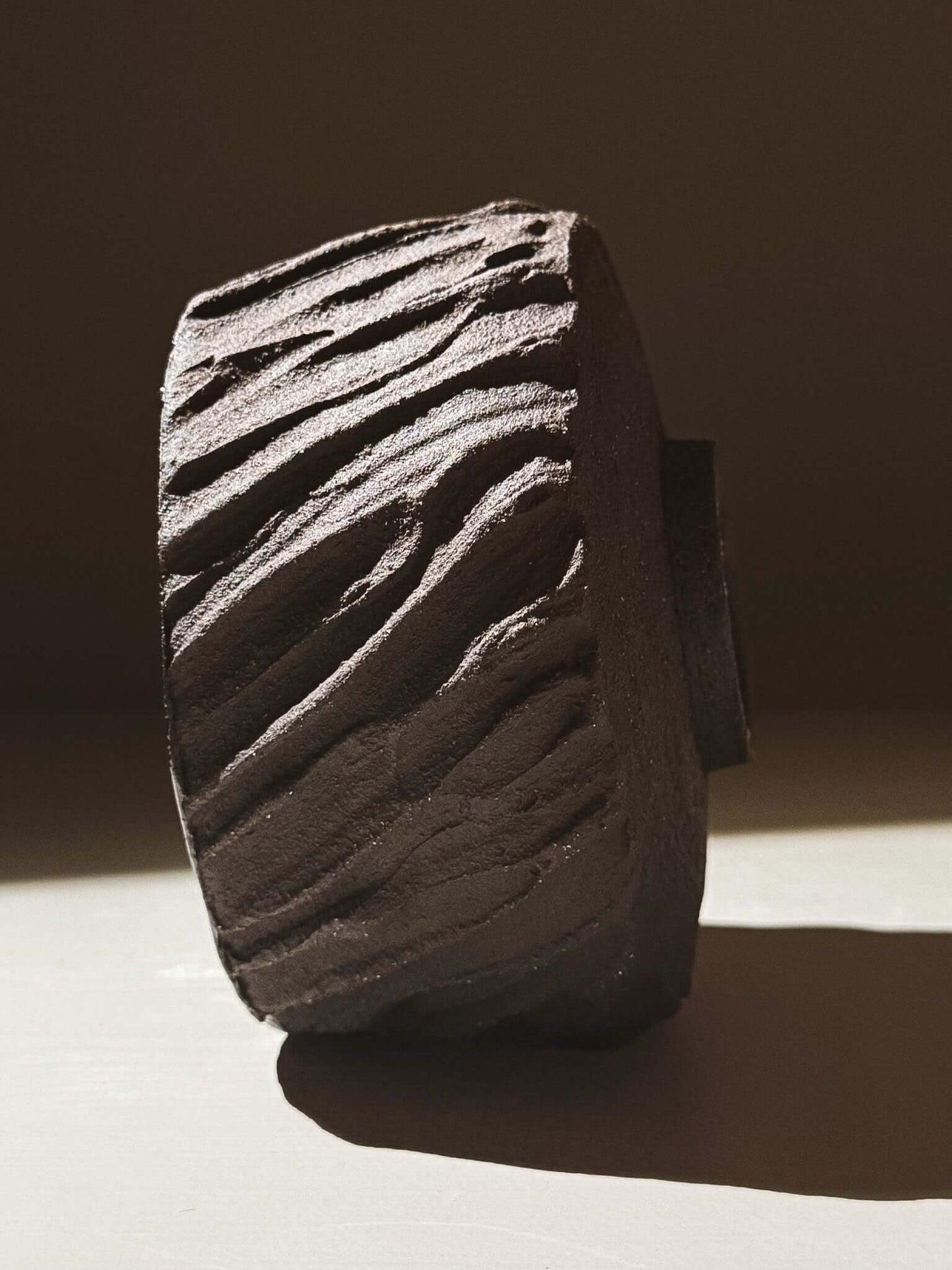 Kuro Matcha Bowl #06 with textured dark brown exterior inspired by volcanic stone, showcasing earthy tones and dynamic surface design.