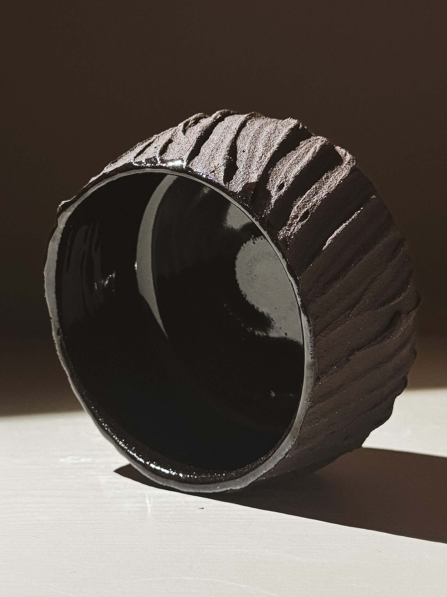 Kuro Matcha Bowl #03 with textured dark brown exterior and glossy interior, inspired by volcanic stone and earthy tones.
