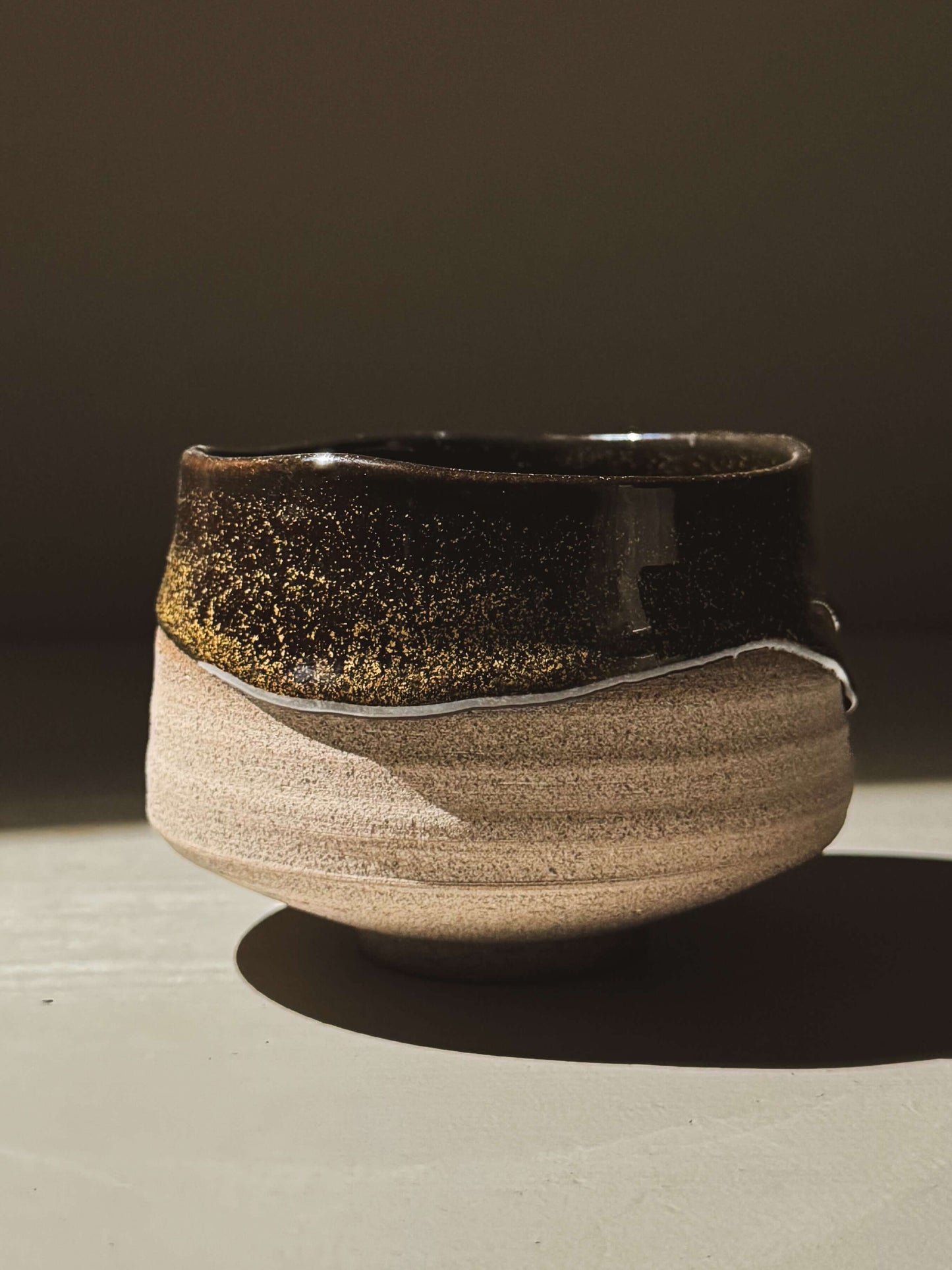 Matcha Bowl – Kuro Ash #02 with ash-grey stoneware and glossy black glaze, showcasing a unique handcrafted design with natural curves.