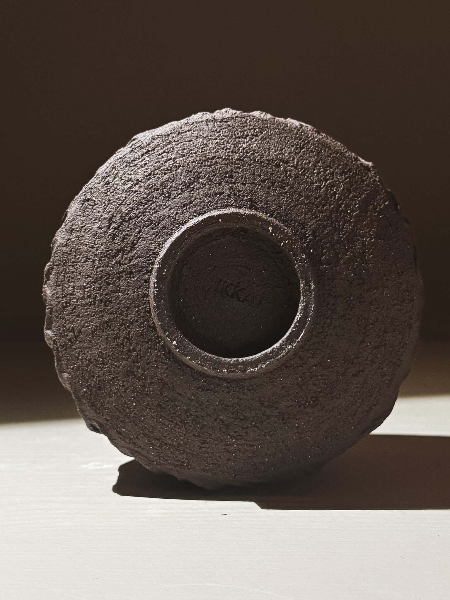 Bottom view of Kuro Matcha Bowl #02 with textured dark brown exterior resembling volcanic stone.
