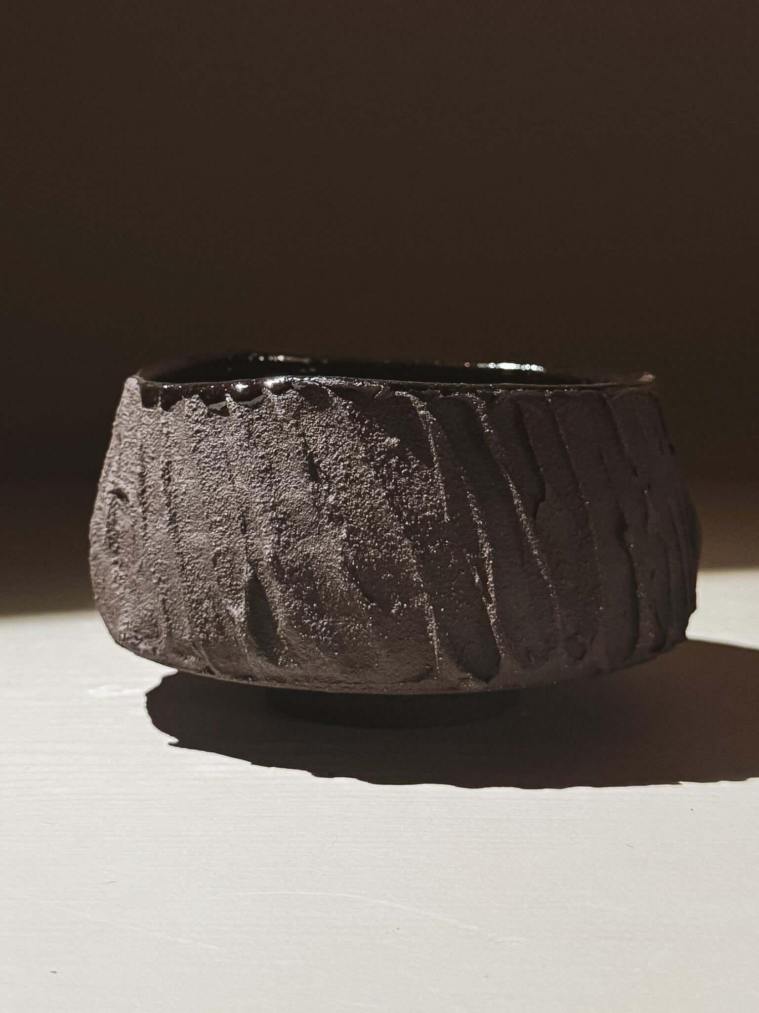 Kuro Matcha Bowl #03 with textured dark brown exterior and glossy interior, inspired by volcanic stone and natural tones.