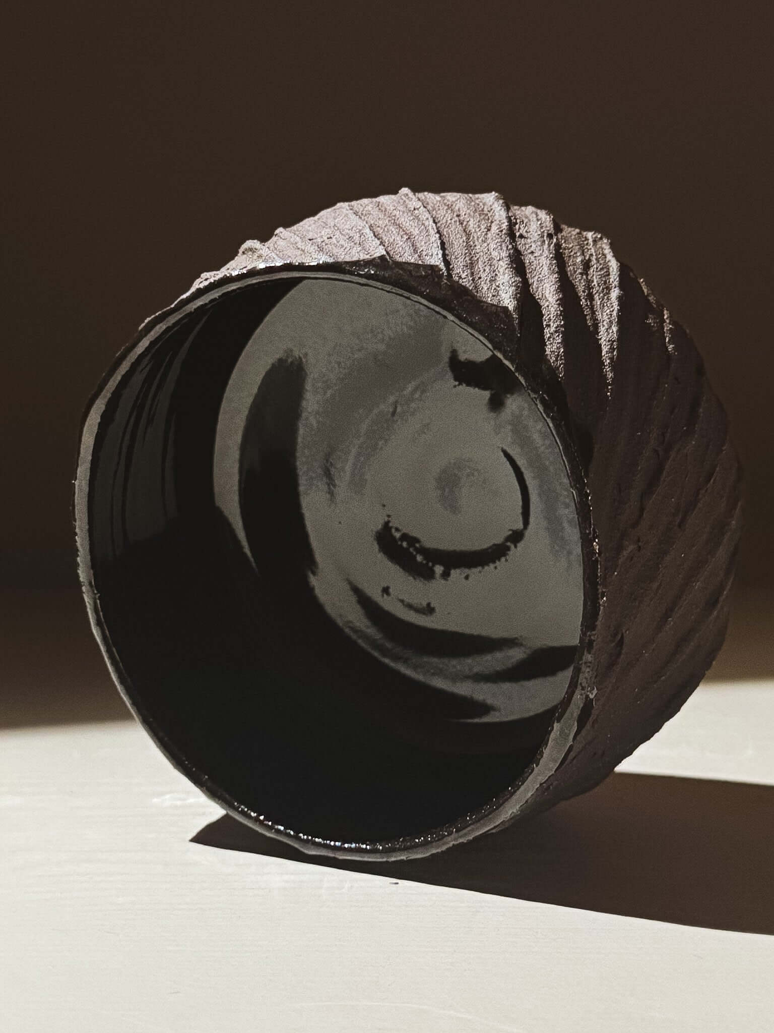Kuro Matcha Bowl #05 with textured dark brown exterior and glossy dark interior reflecting light beautifully.