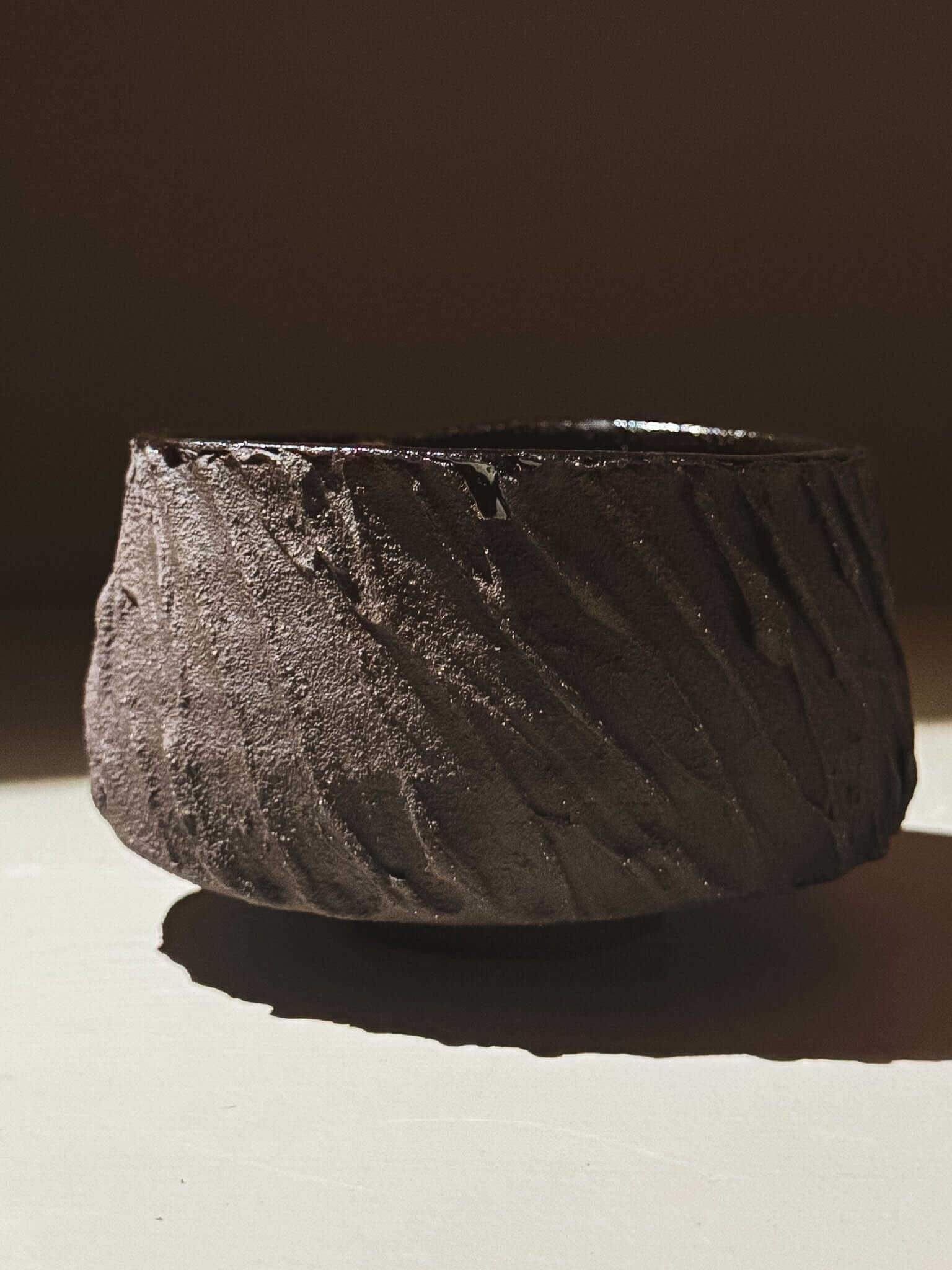 Kuro Matcha Bowl #06 with textured dark brown exterior and glossy dark interior, inspired by volcanic stone and natural tones