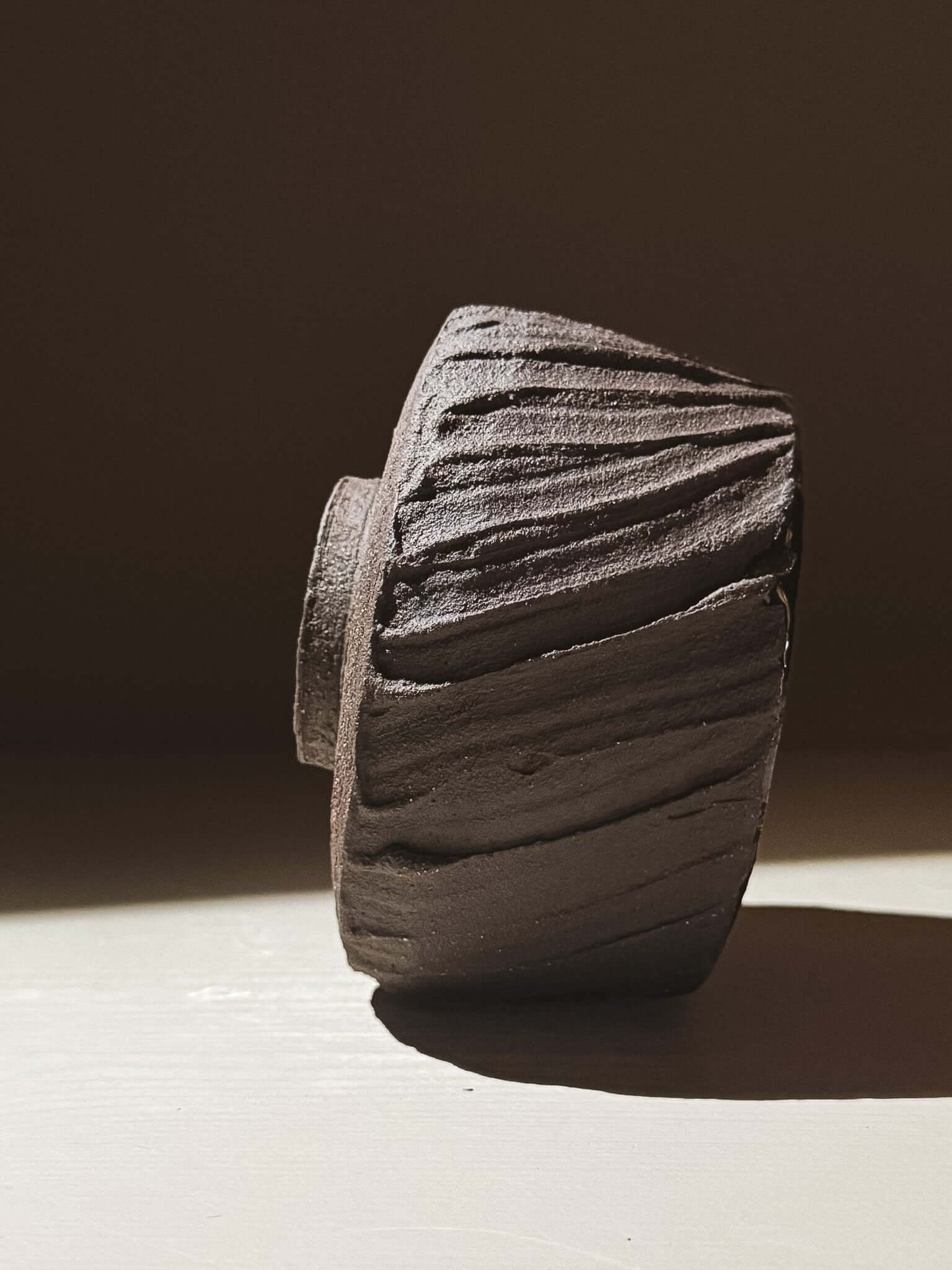 Kuro Matcha Bowl #07 with textured dark brown slip finish, inspired by volcanic stone, showing rough exterior and smooth glazed interior.