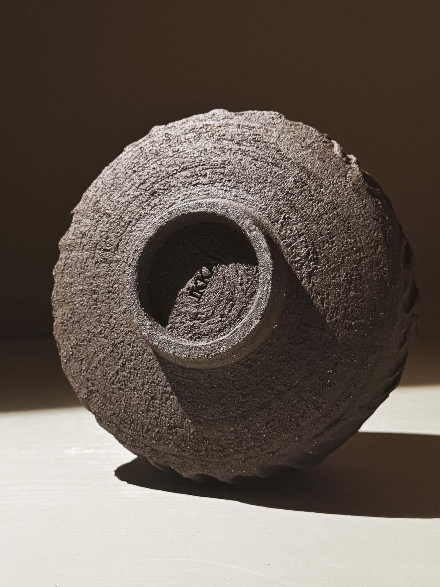 Kuro Matcha Bowl #08 showcasing volcanic stone-inspired texture and earthy dark brown slip on bottom view