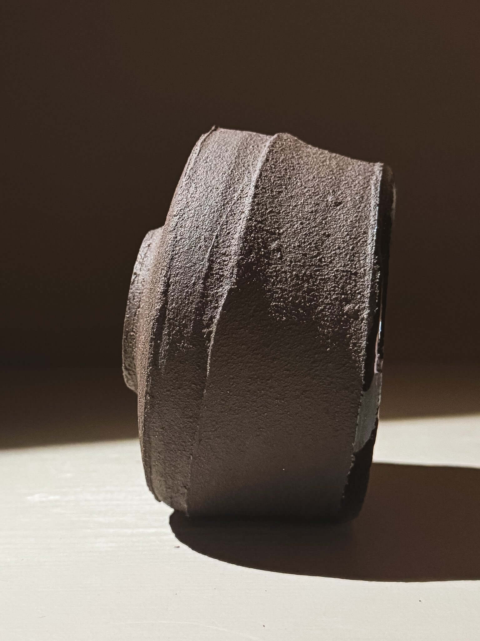 Kuro Matcha Bowl #09 with textured dark brown slip and glossy interior, inspired by volcanic stone and earthy textures.