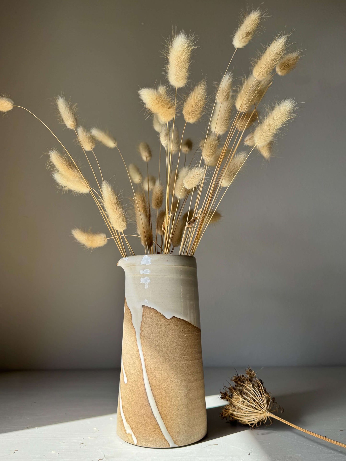 Large Vase / Jug – Yuki Series handmade ceramic with a glossy white glaze and raw toffee clay base with decorative dried grasses.