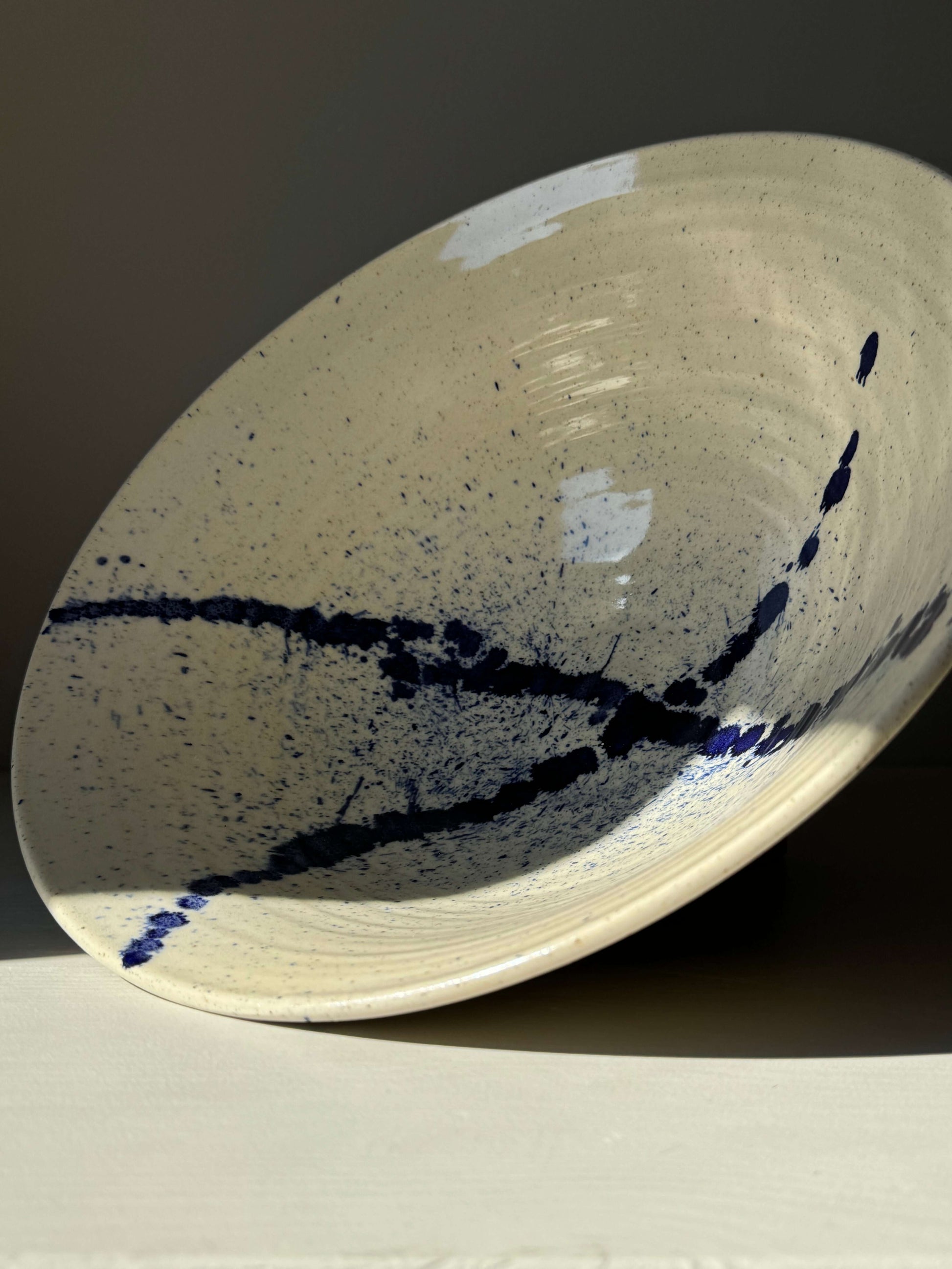 Large bowl from Gosu Series with deep cobalt blue splashes on the interior, showcasing artistic design and natural exterior.
