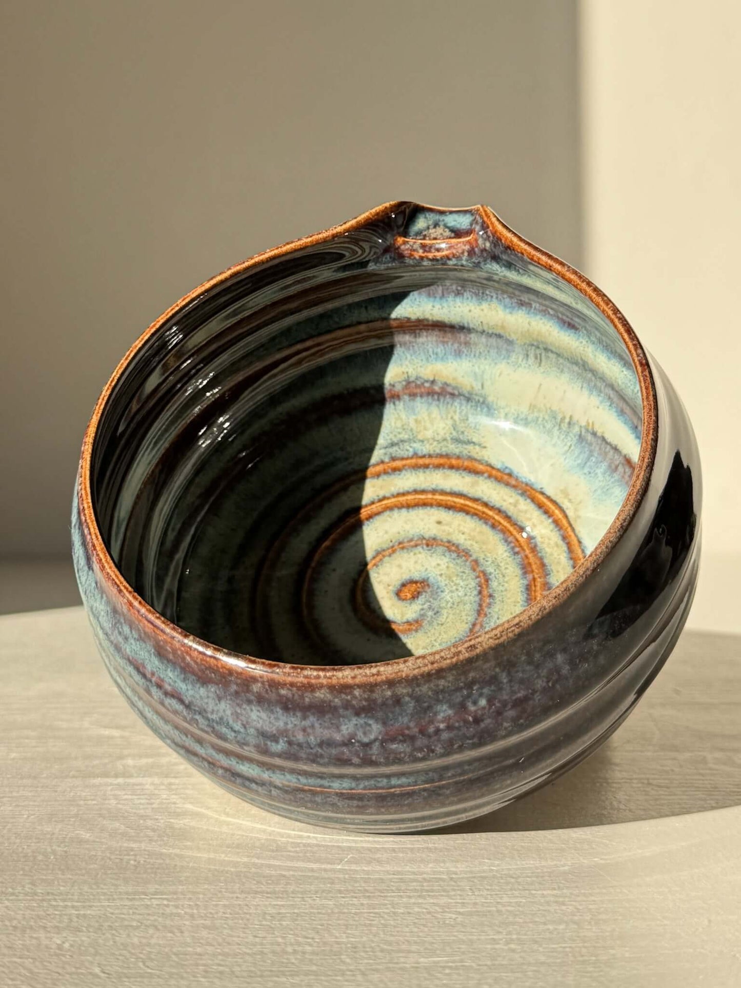 Matcha Bowl Spout - Glossy Blue #01 with swirling earthy tones and a pouring spout, showcasing unique handcrafted design on a raised foot.