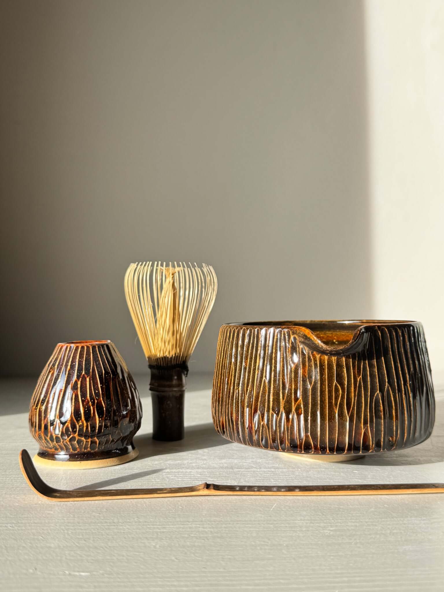 Matcha Bowl Spout – Kinsei #03 with handcrafted design, featuring golden and brown vertical lines, alongside traditional matcha accessories.