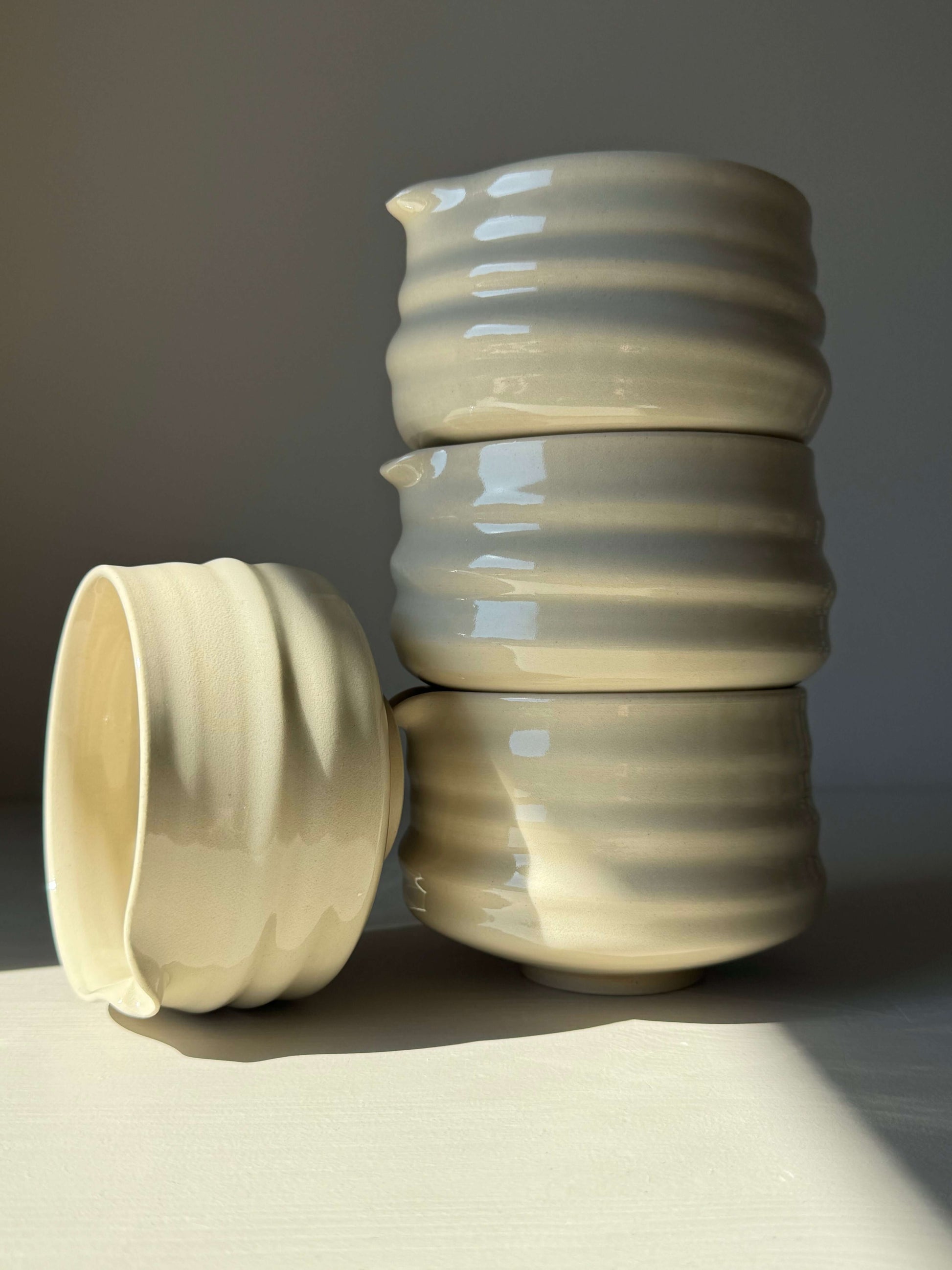 Stack of matcha bowls with spout in clear glaze, showing ridged design and natural clay finish, perfect for whisking matcha.