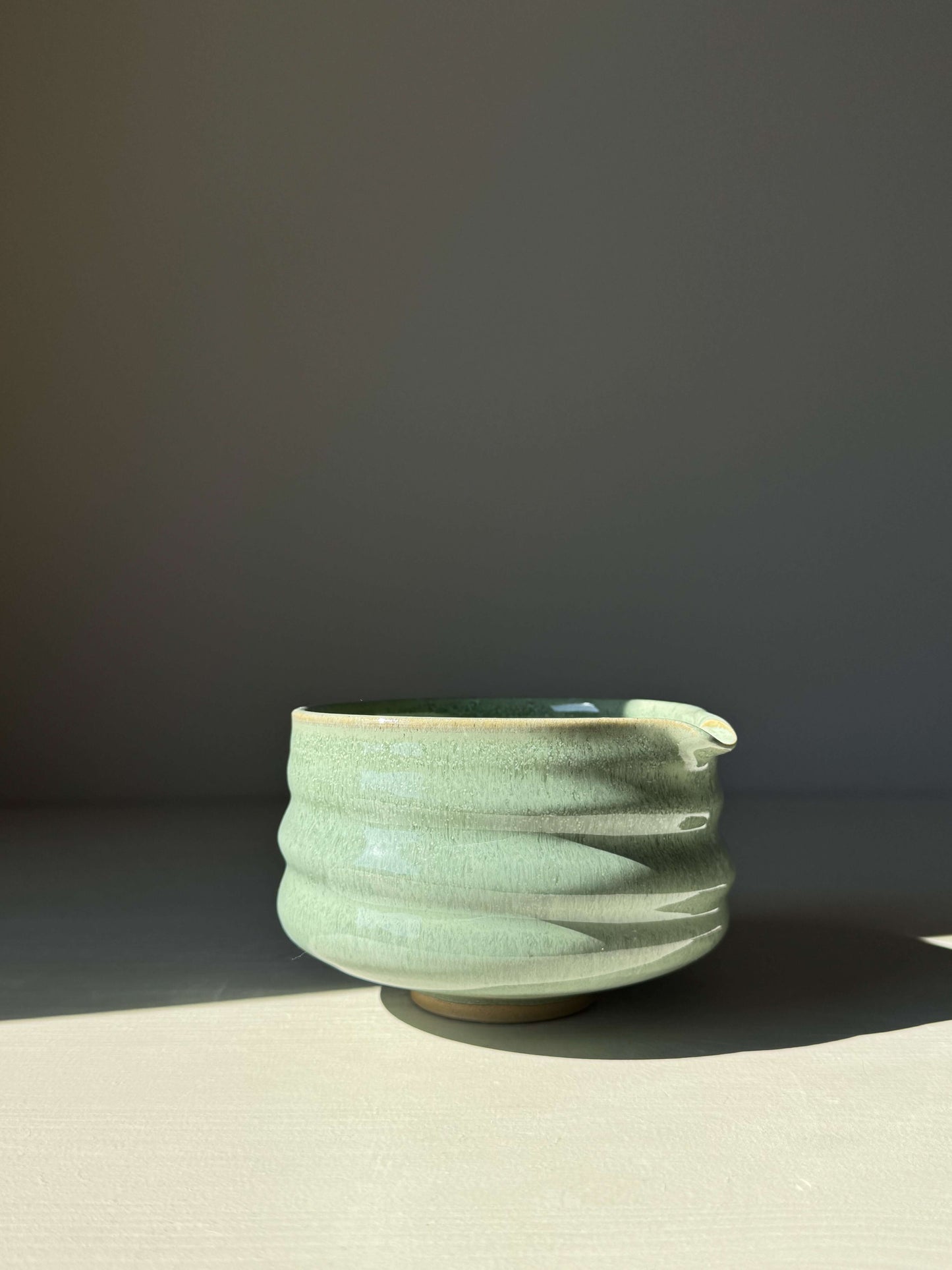 Sage glaze matcha bowl with spout and ridges, featuring a glossy finish and earthy tones, perfect for elevating matcha rituals.
