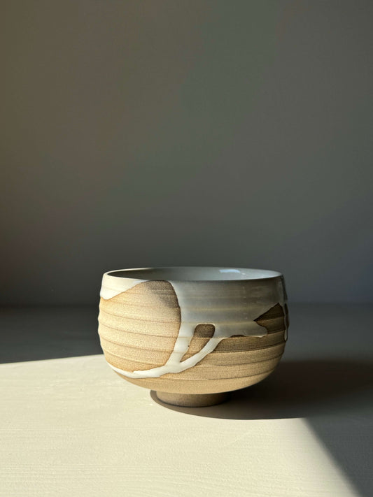 Handmade Matcha bowl from Yuki Series #07 with toffee clay and white glaze, wheel-thrown and unique in a serene setting.