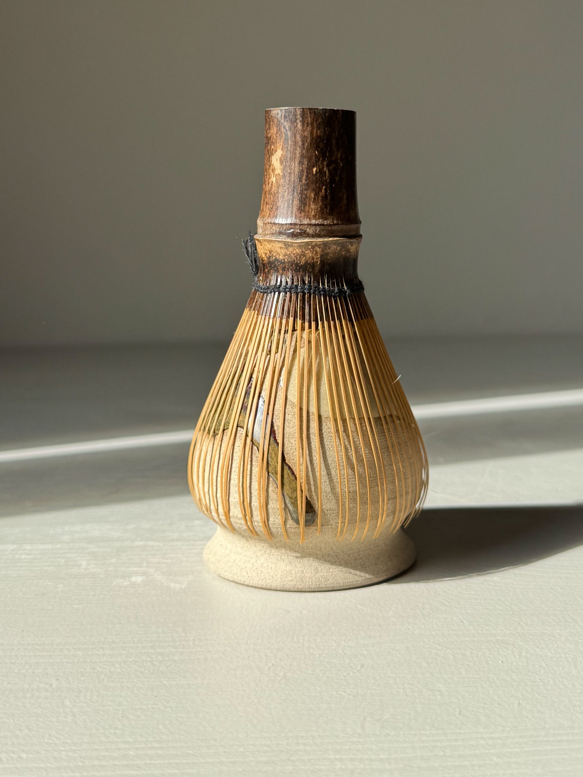 Matcha Whisk Holder - Inyo Series, handmade ceramic with bamboo whisk on display, elegant design with glossy tenmoku and warm toffee clay.