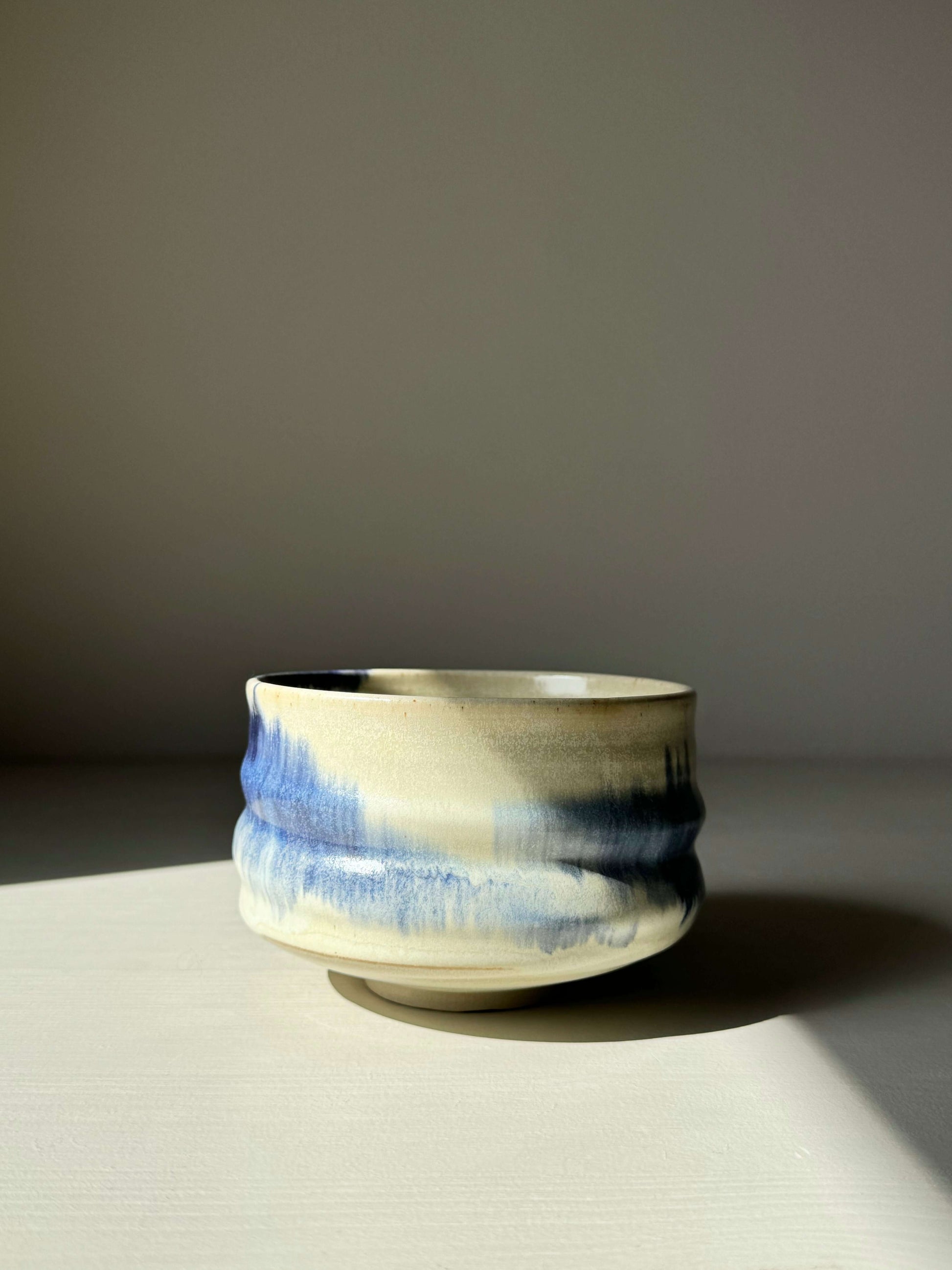 Cobalt blue and moonstone glazed matcha bowl with a unique hand-splashed design, showcasing a rounded shape and serene aesthetic.