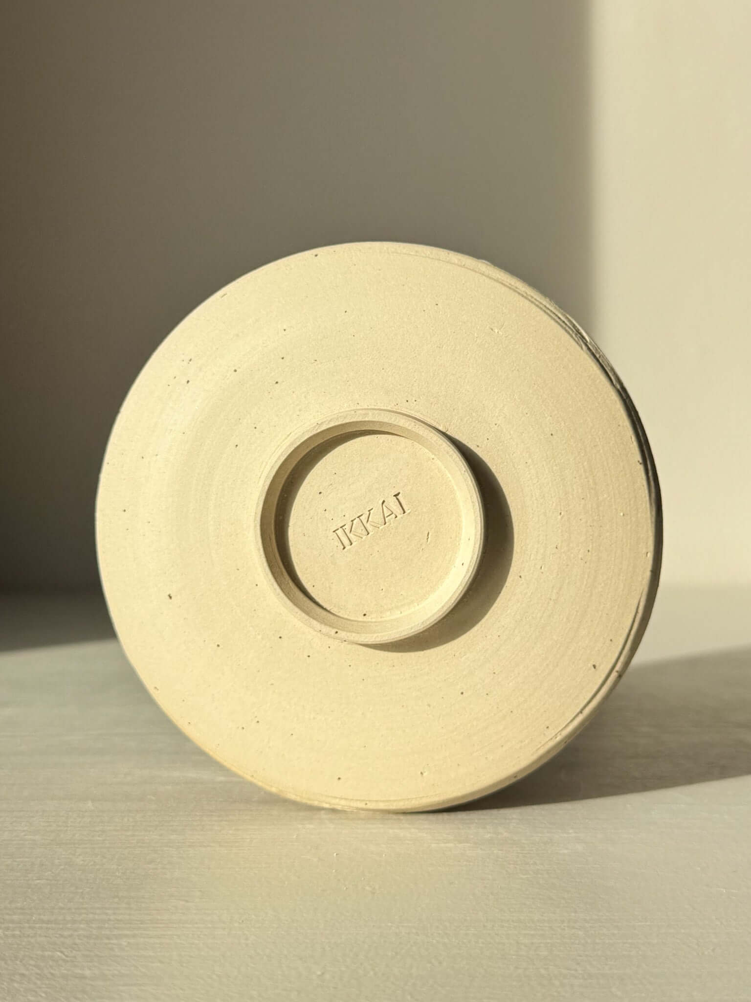 Underside view of Matcha Bowl – Glossy White #05 showing unglazed speckled stoneware clay base.