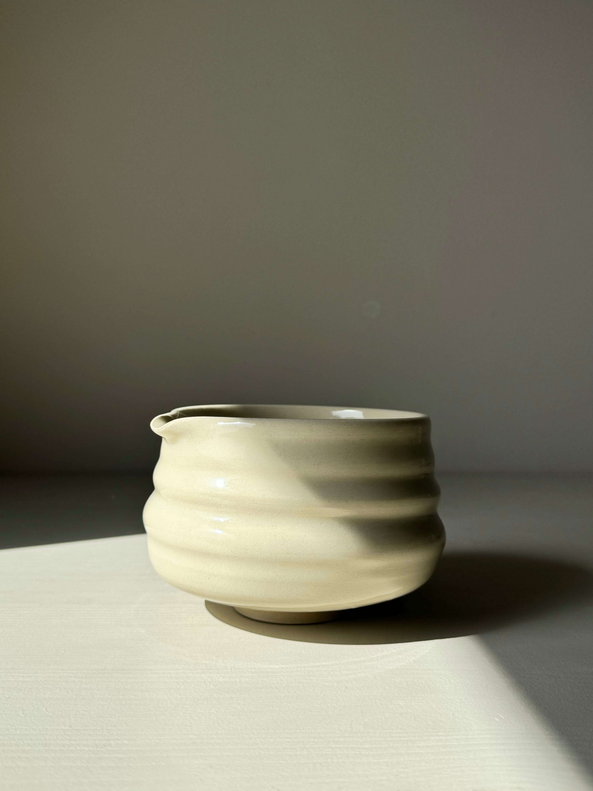 Handcrafted matcha bowl with spout, featuring clear glaze and subtle ridges, 7.5cm height x 11cm diameter, perfect for smooth whisking.