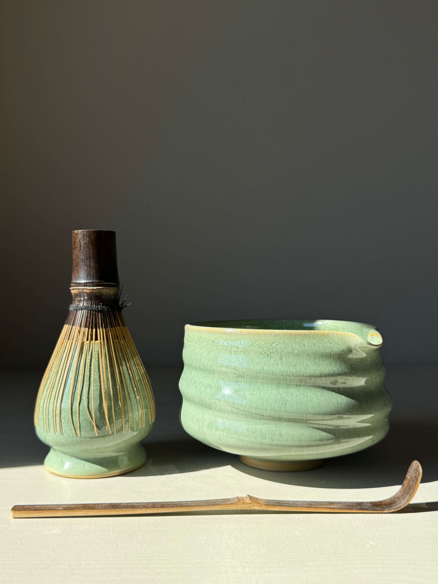 Matcha whisk holder with sage glaze, showcasing bamboo whisk and ceramic bowl. Perfect tool for preserving whisk shape and longevity.
