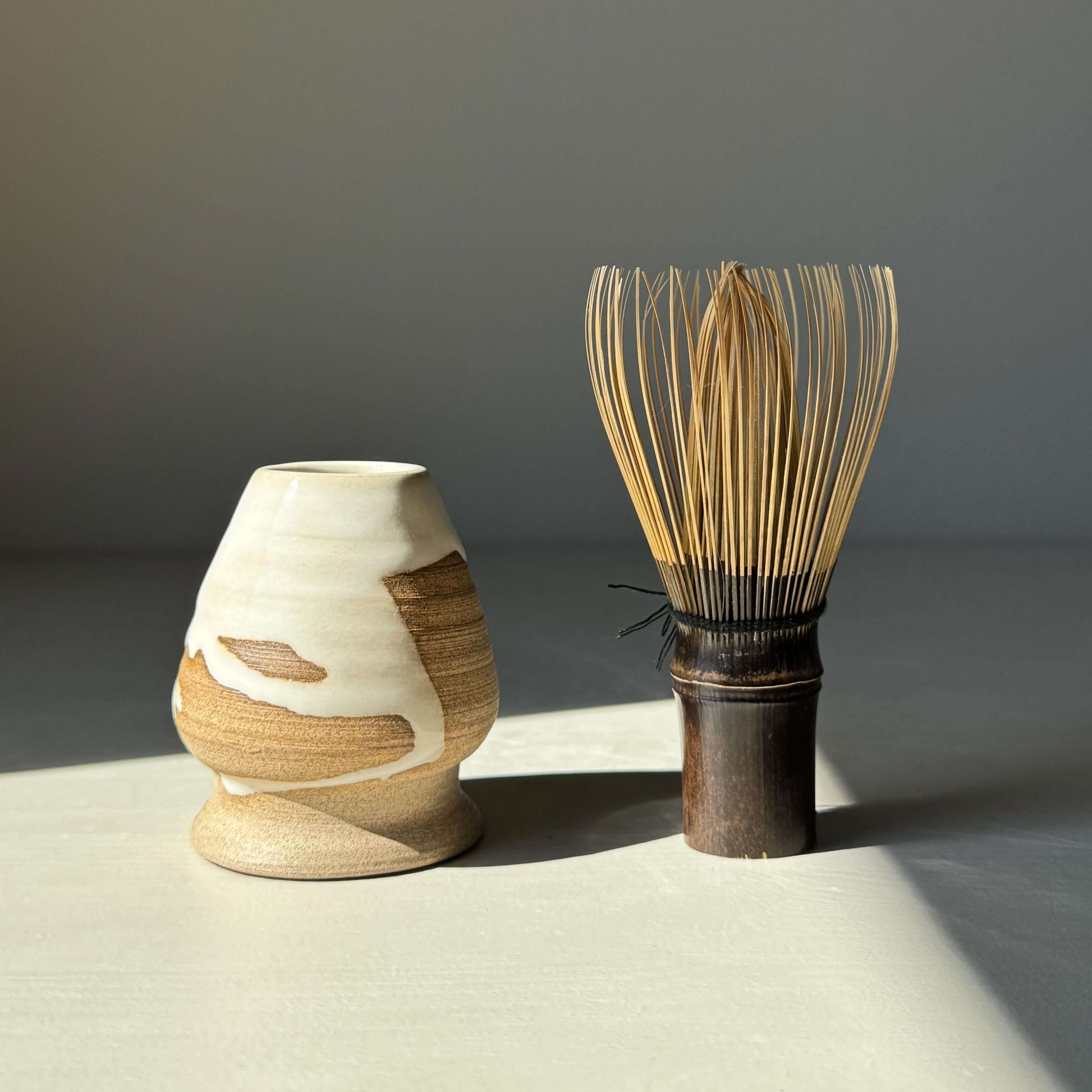 Matcha Whisk Holder from Yuki Series with bamboo whisk, featuring a glossy white glaze and natural toffee clay design.