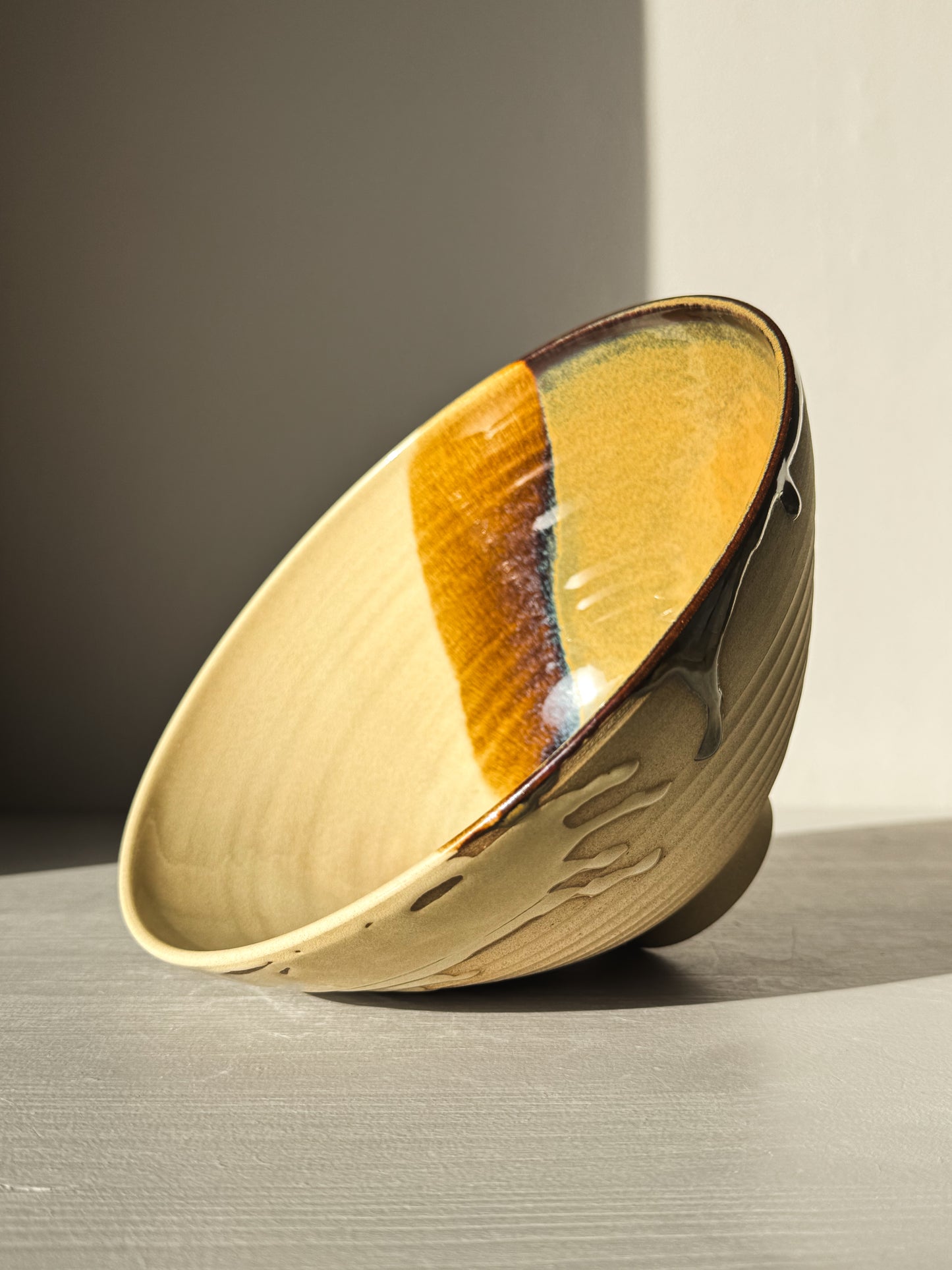 Medium Carved Bowl - Inyo #01 with golden, brown, and blue tones, carved exterior, and drip details on the rim in sunlight.