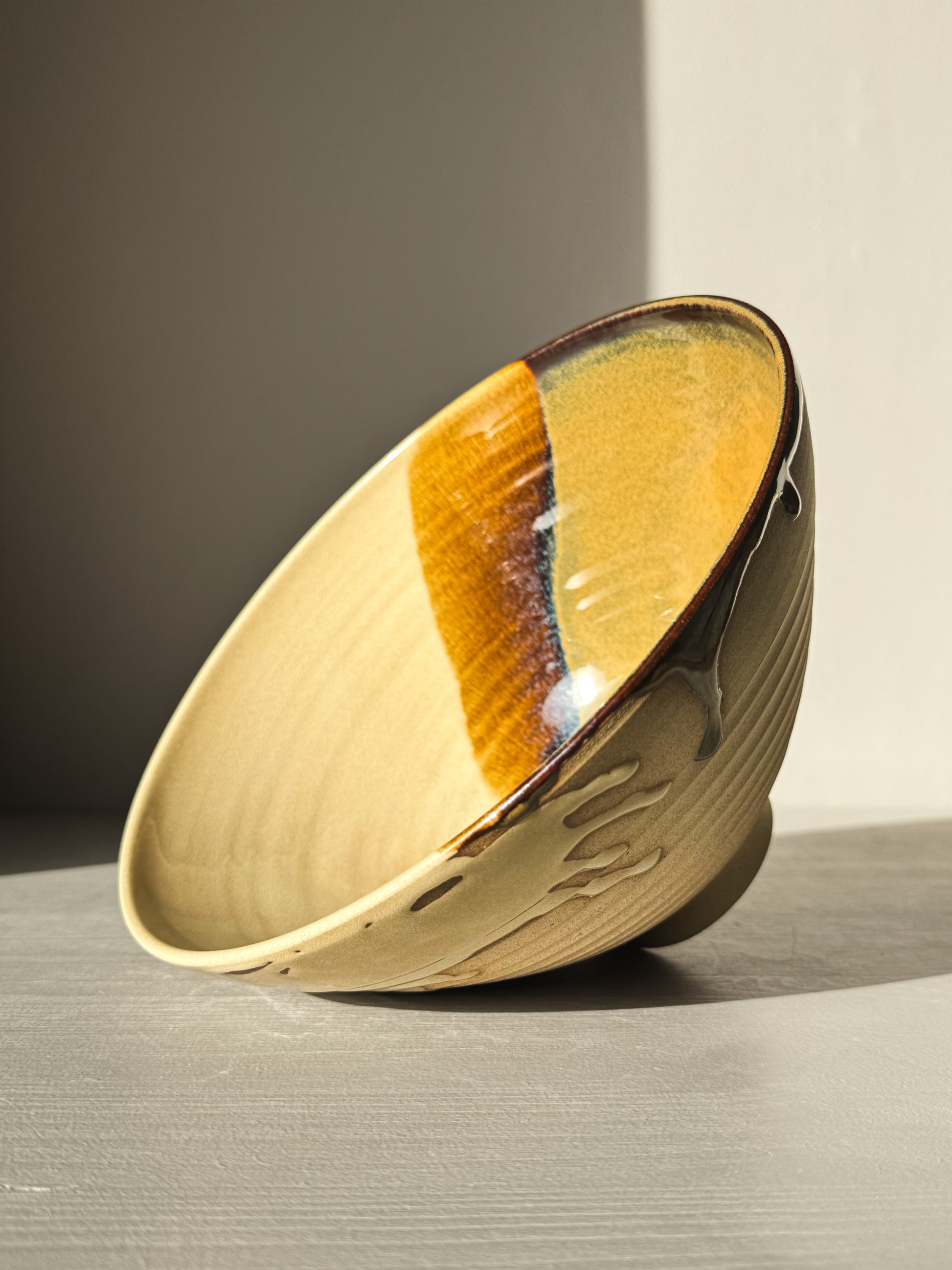 Medium Carved Bowl - Inyo #01 with golden, brown, and blue tones, carved exterior, and drip details on the rim in sunlight.