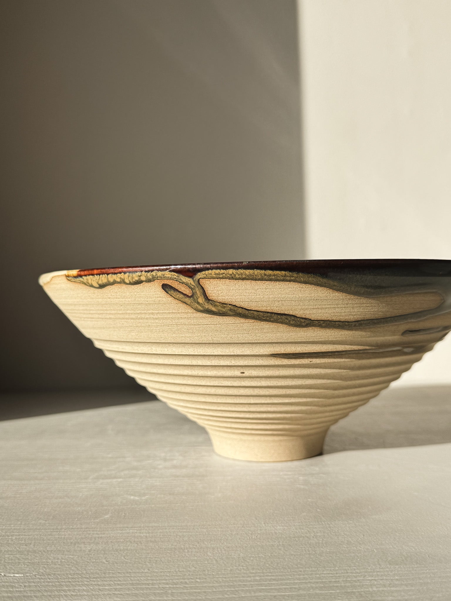 Medium Carved Bowl - Inyo #02 with expressive glaze featuring golds, browns, blue, and green, sculptural carved exterior and raw clay texture