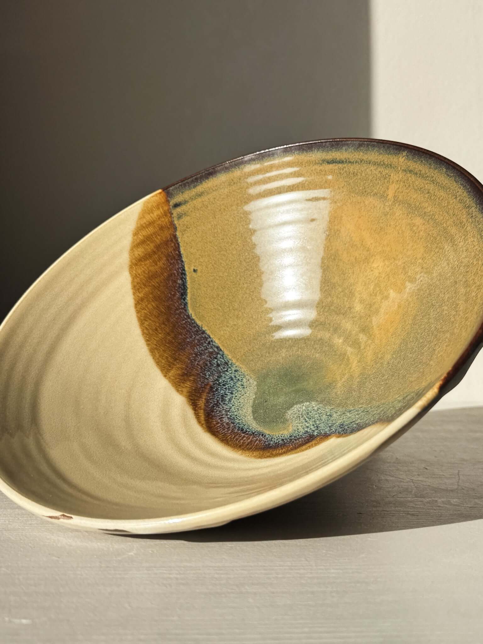 Medium Carved Bowl - Inyo #02 with warm gold, brown, blue, and green glaze and carved exterior, creating a sculptural and expressive look.