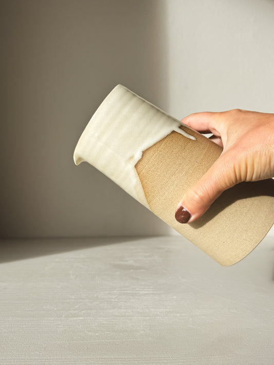 Medium Vase/Jug – Yuki #02 held by hand, showing glossy white glaze on toffee-colored clay with sculptural design.