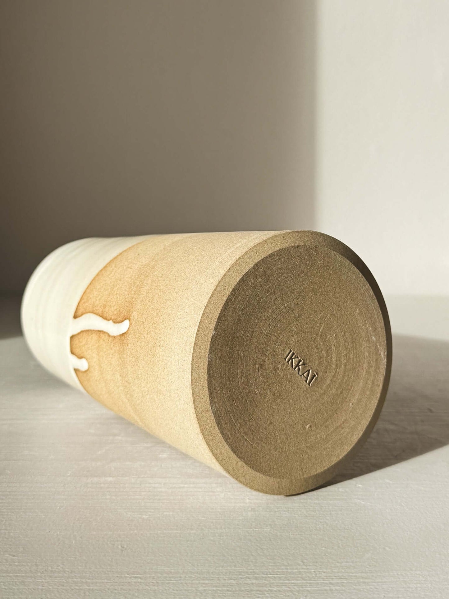 Base of Medium Vase/Jug – Yuki #02, showing raw toffee clay and glossy white glaze contrast in sunlight.