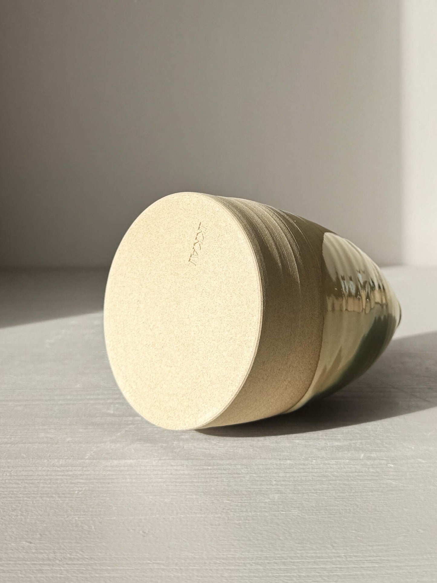 Bottom view of Medium Vase – Mori #01 showing the soft earthy warmth of the clay and the gentle flowing green glaze on a rounded shape.