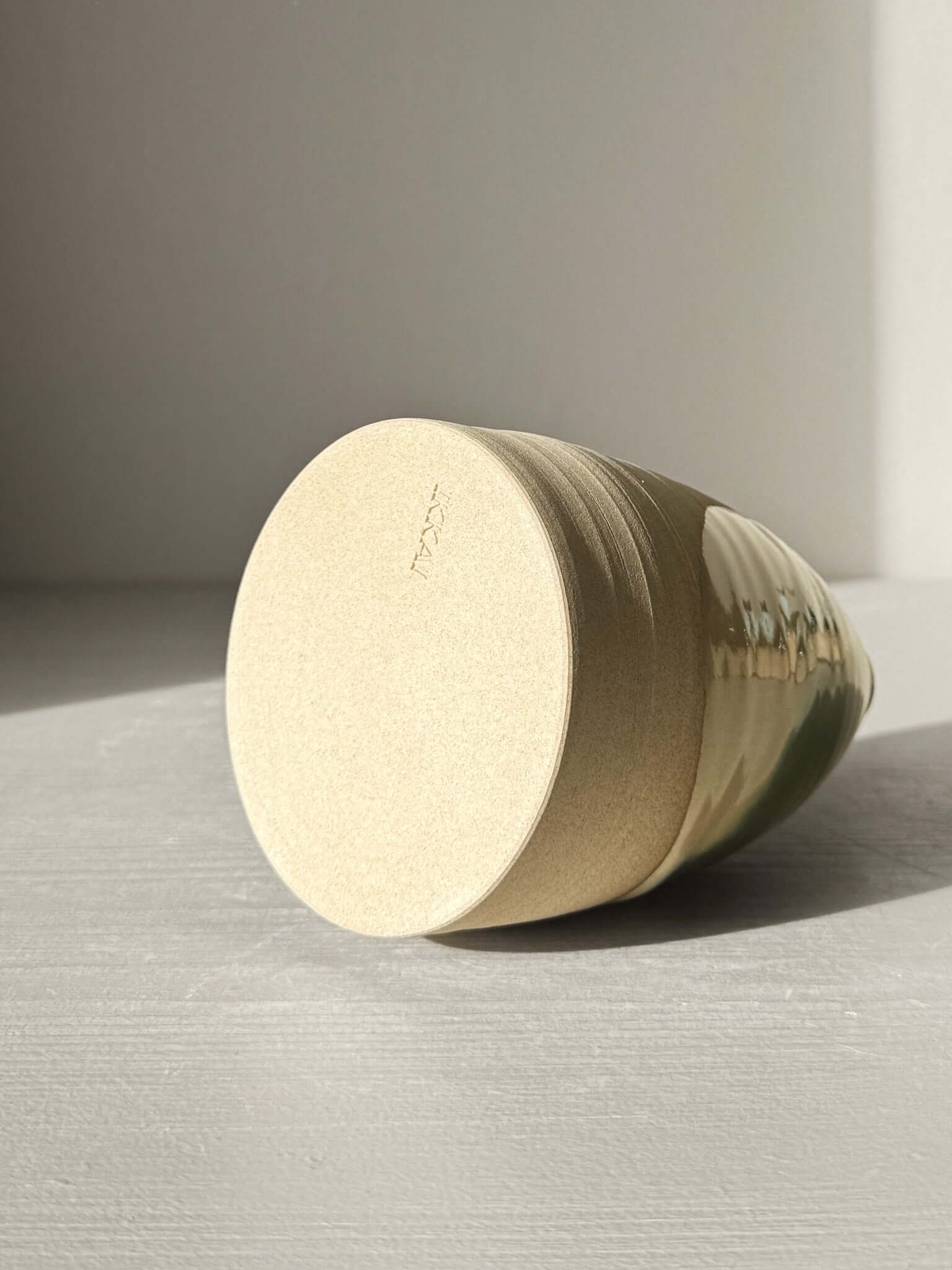 Bottom view of Medium Vase – Mori #01 showing the soft earthy warmth of the clay and the gentle flowing green glaze on a rounded shape.