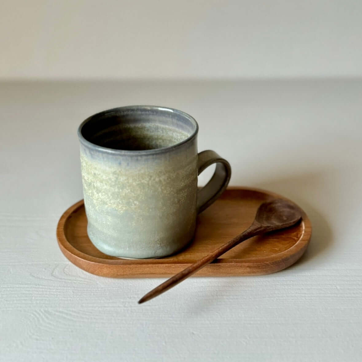 Medium wooden spoons with ceramic mug on wooden tray
