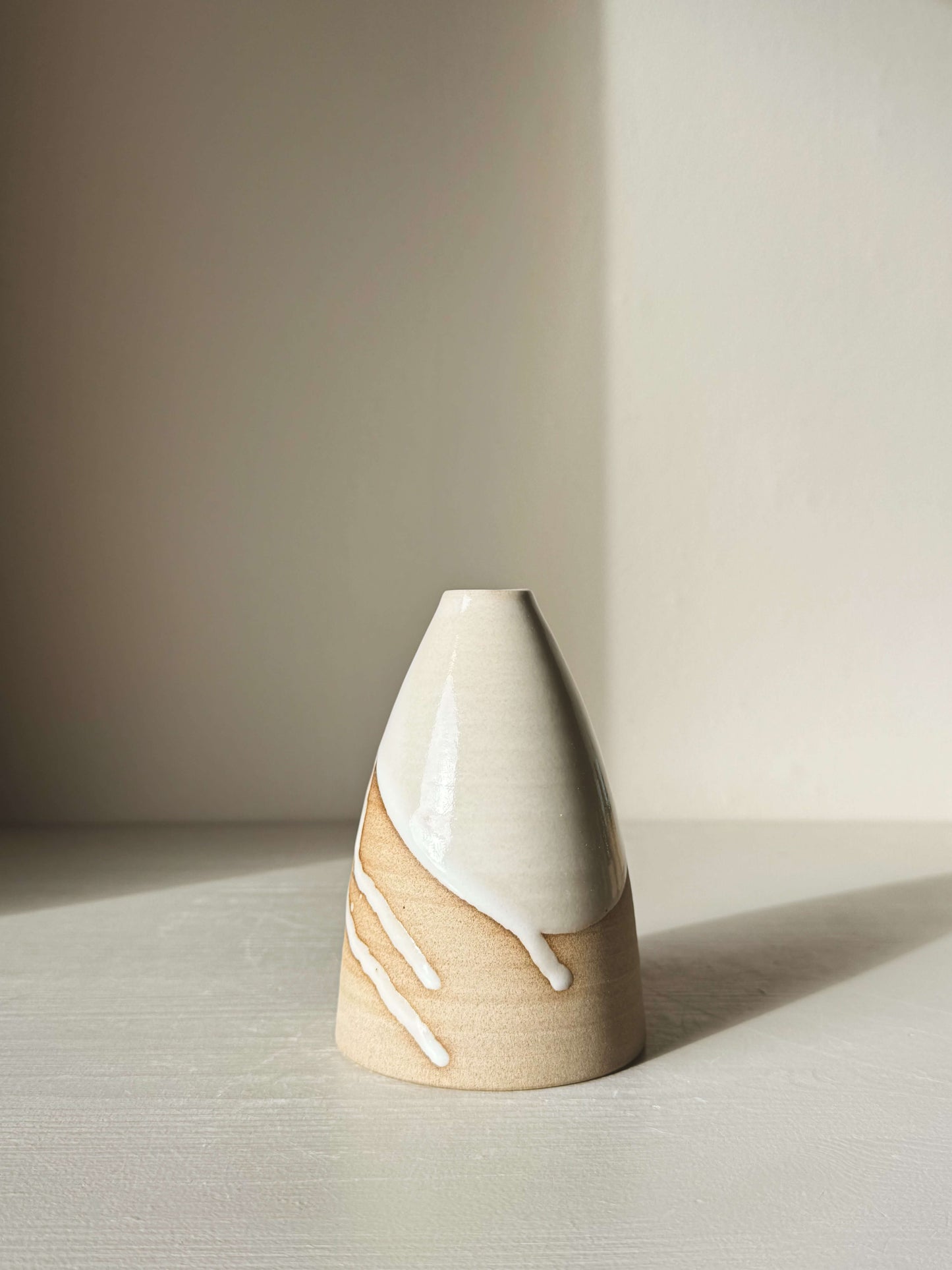 Medium Vase – Yuki #04 displayed with white glaze over warm clay, showcasing its tall, rounded shape and elegant design.