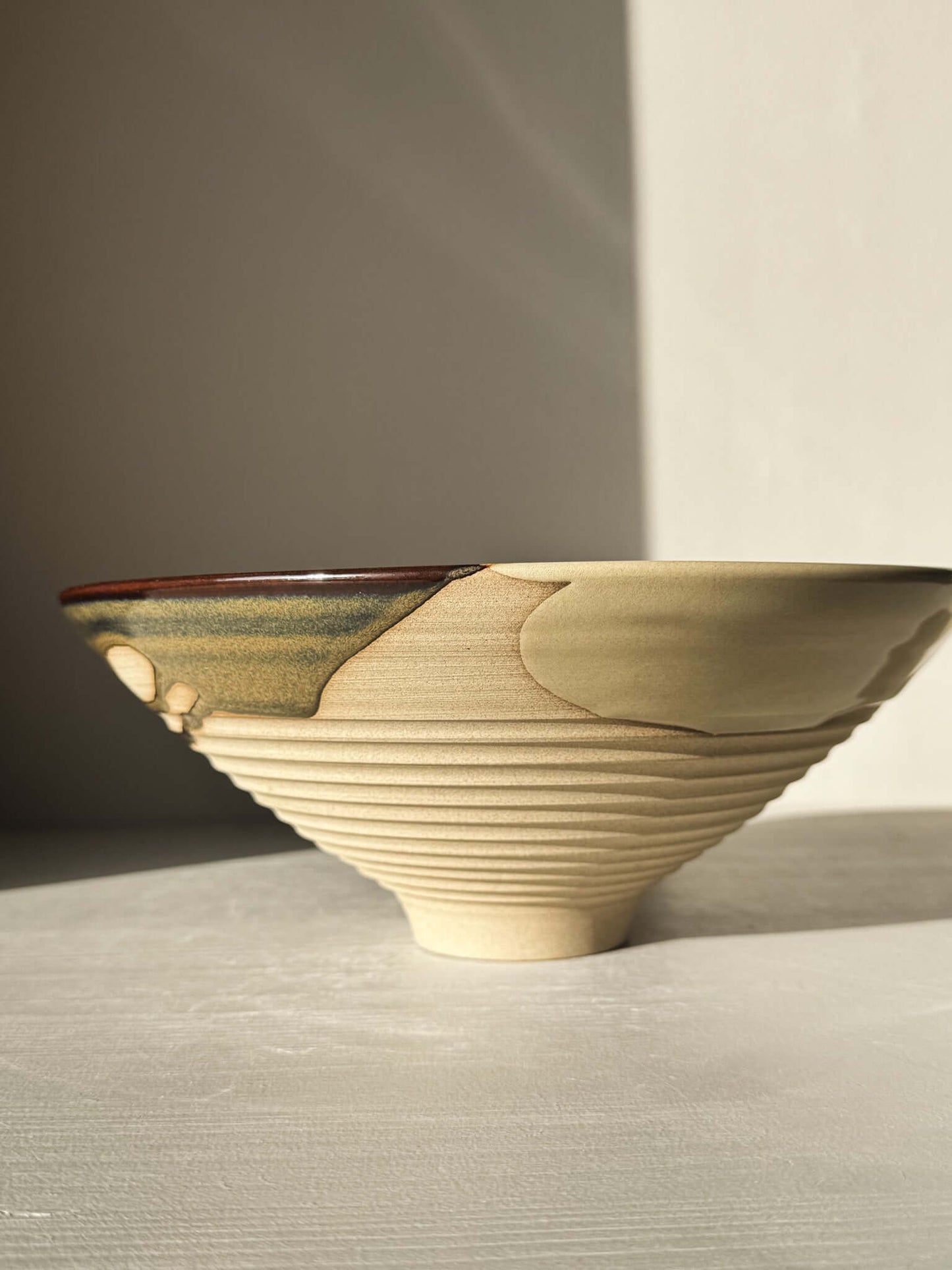 Medium Carved Bowl - Inyo #02 with gold, brown, and blue glazes; sculptural look with carved exterior and raw clay texture.