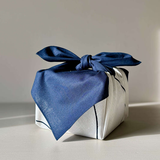Medium navy blue Furoshiki wrapping cloth on a gift, showcasing pine, bamboo, and plum motifs for prosperity and good fortune.