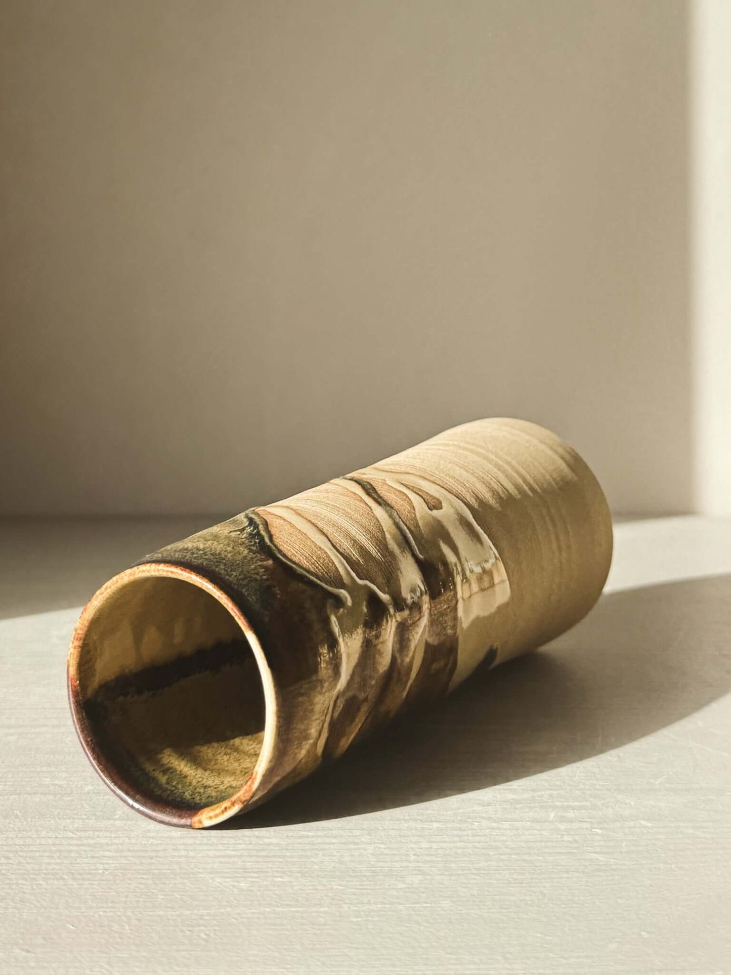 Medium Vase - Inyo Series with tenmoku glaze and raw clay texture, highlighting its tall sculptural design in natural lighting.