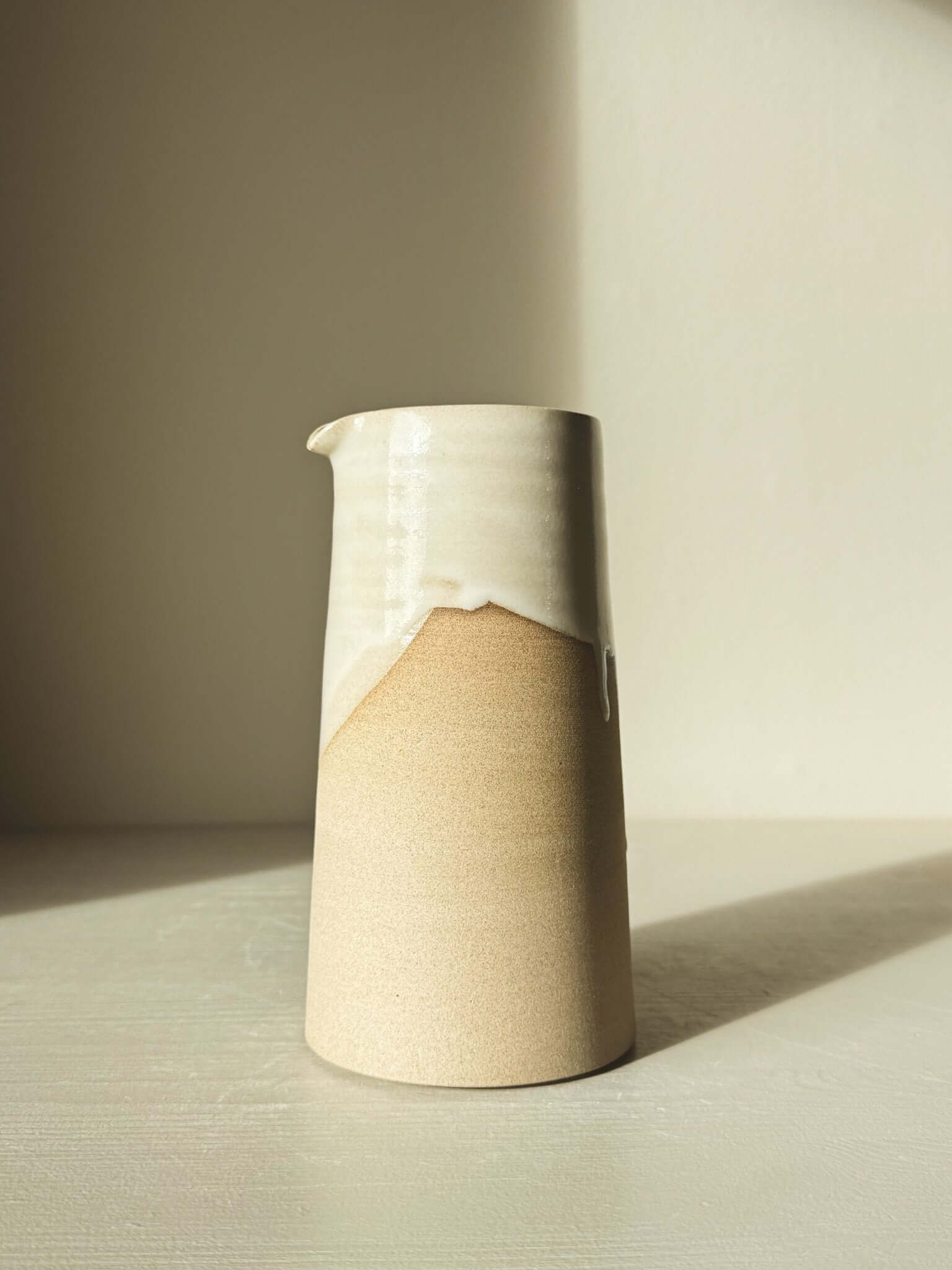 Tall Medium Vase/Jug – Yuki #02 with glossy white glaze over carved toffee-colored clay, showcasing elegant sculptural design.