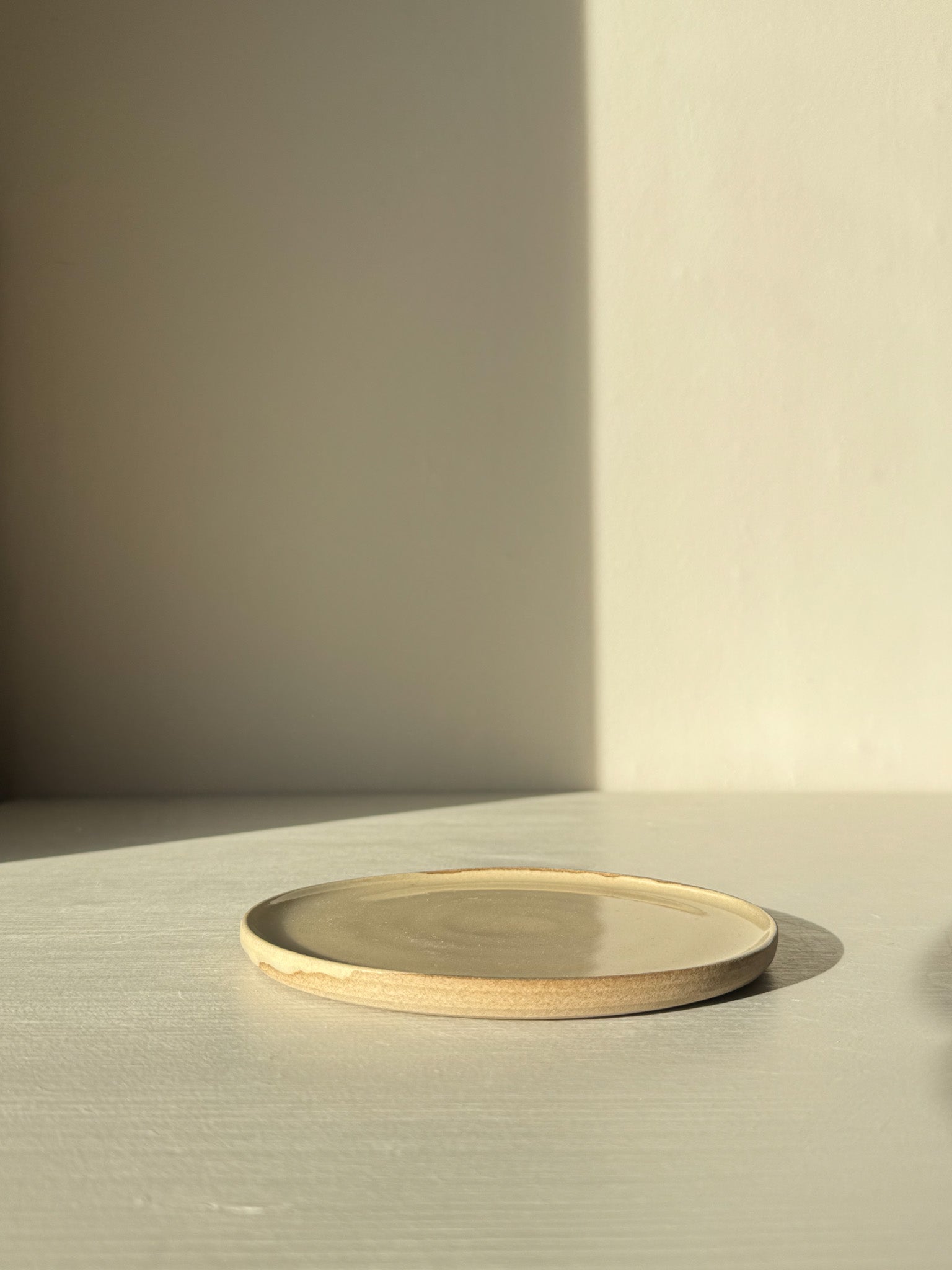 Minimalist ceramic plate with beige and cream tones on a light surface